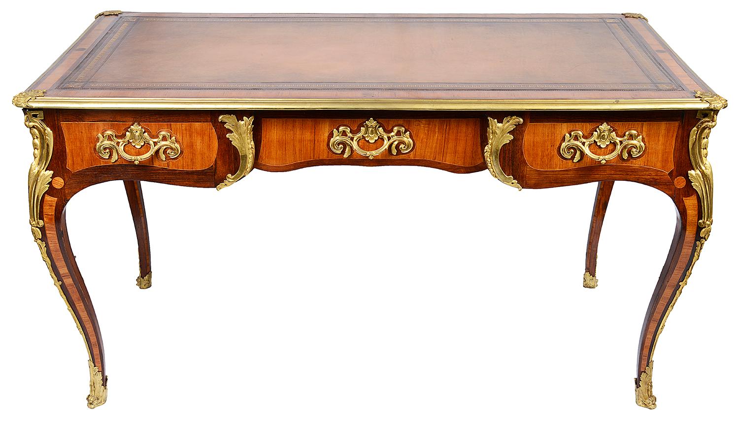 A good quality late 19th century French mahogany and satinwood bureau plat, having an inset leather with gilded tooling, three frieze drawer with oak linings, dummy drawers to the reverse, wonderful gilded ormolu Rococo handles, raised on elegant
