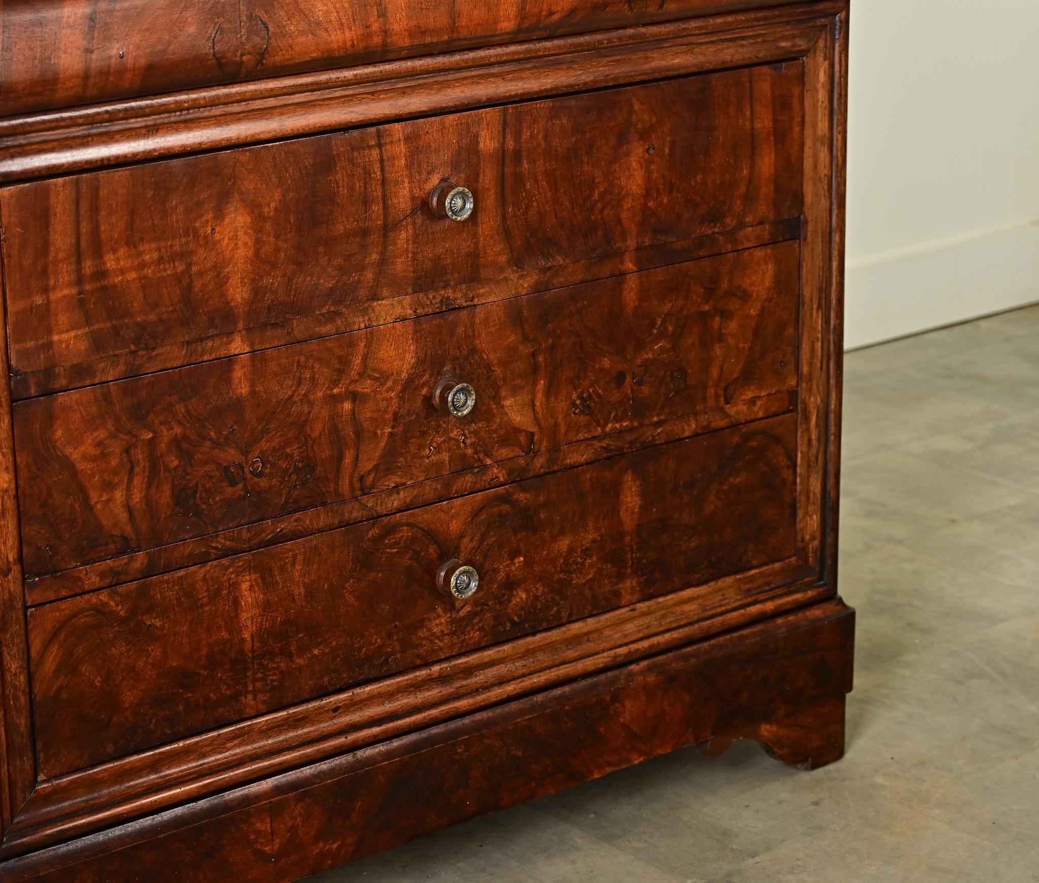 Questa commode di Louis Philippe, proveniente dalla Francia del XIX secolo, presenta alcune sorprese: i frontali dei cassetti in noce burlato sono così sorprendenti per la fitta trama delle venature che è facile non notare la presenza di cassetti