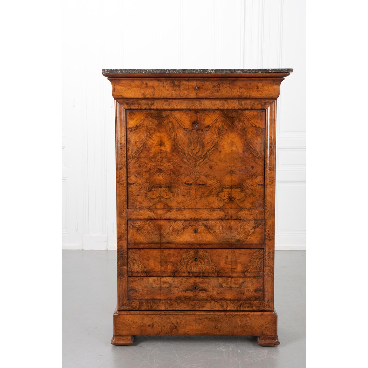 A wonderful French 19th century burl walnut secretaire a abattant has a Sainte-Anne marble top. A single drawer can be found at the top of the desk with a key. The front of the desk folds down when unlocked, revealing a green felt work surface at