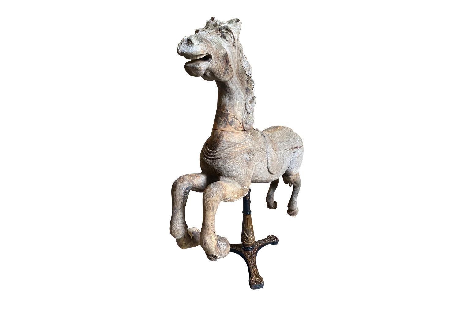 A wonderfully charming 19th century Carousel Horse from the South of France.  Beautifully crafted from naturally washed pine resting on its iron stand.  The iron stand has a spring allowing the horse to gently rock.  Fabulous patina.