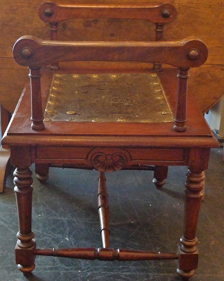 French 19th century carved and stained walnut bench with zinc seat and two side arms and three stretchers.