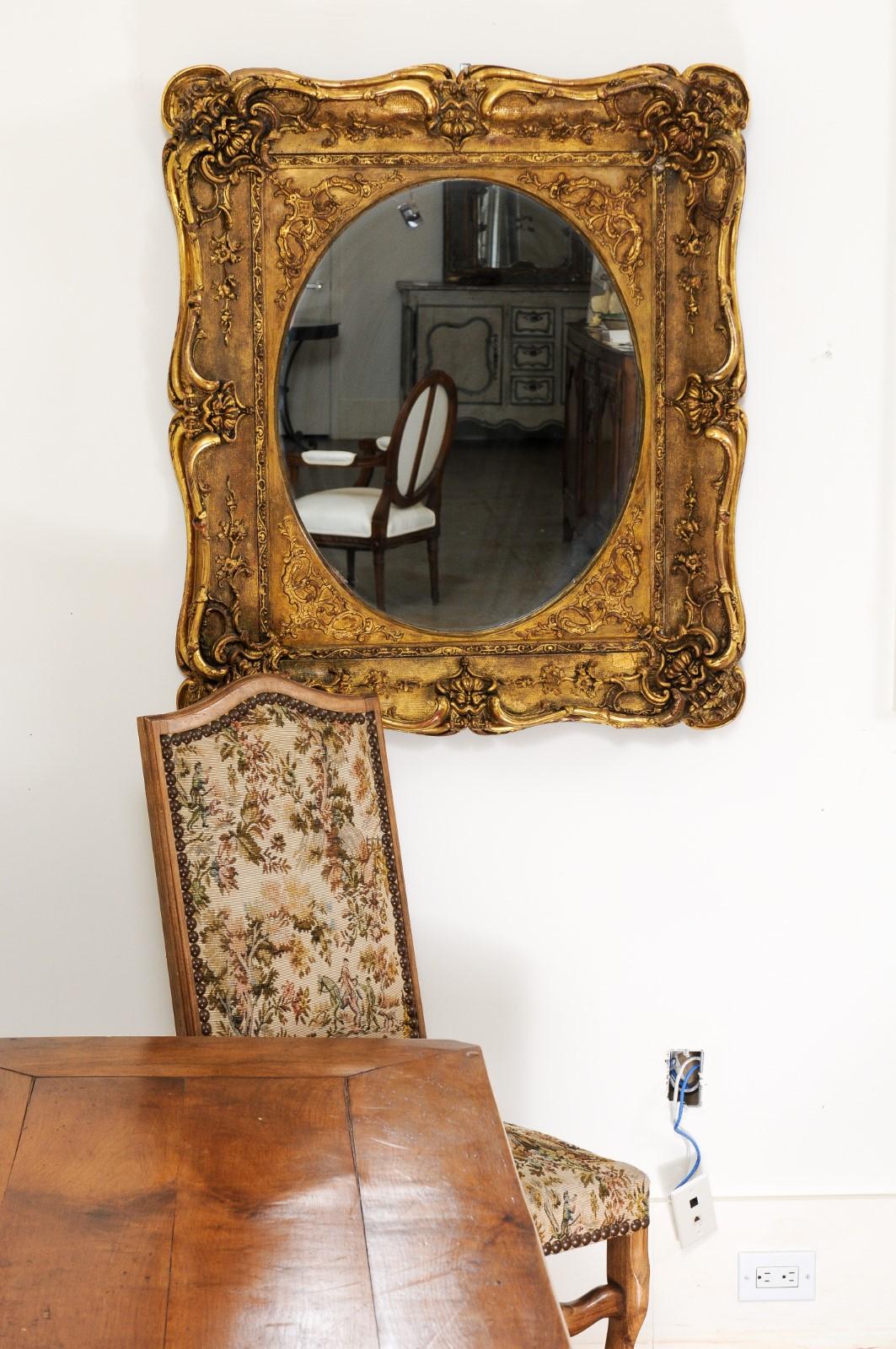A French carved giltwood mirror from the 19th century, with scrolling foliage and delicate flowers. Created in France during the 19th century, this giltwood mirror attracts our attention with its graceful scrolling lines showcasing foliage, delicate