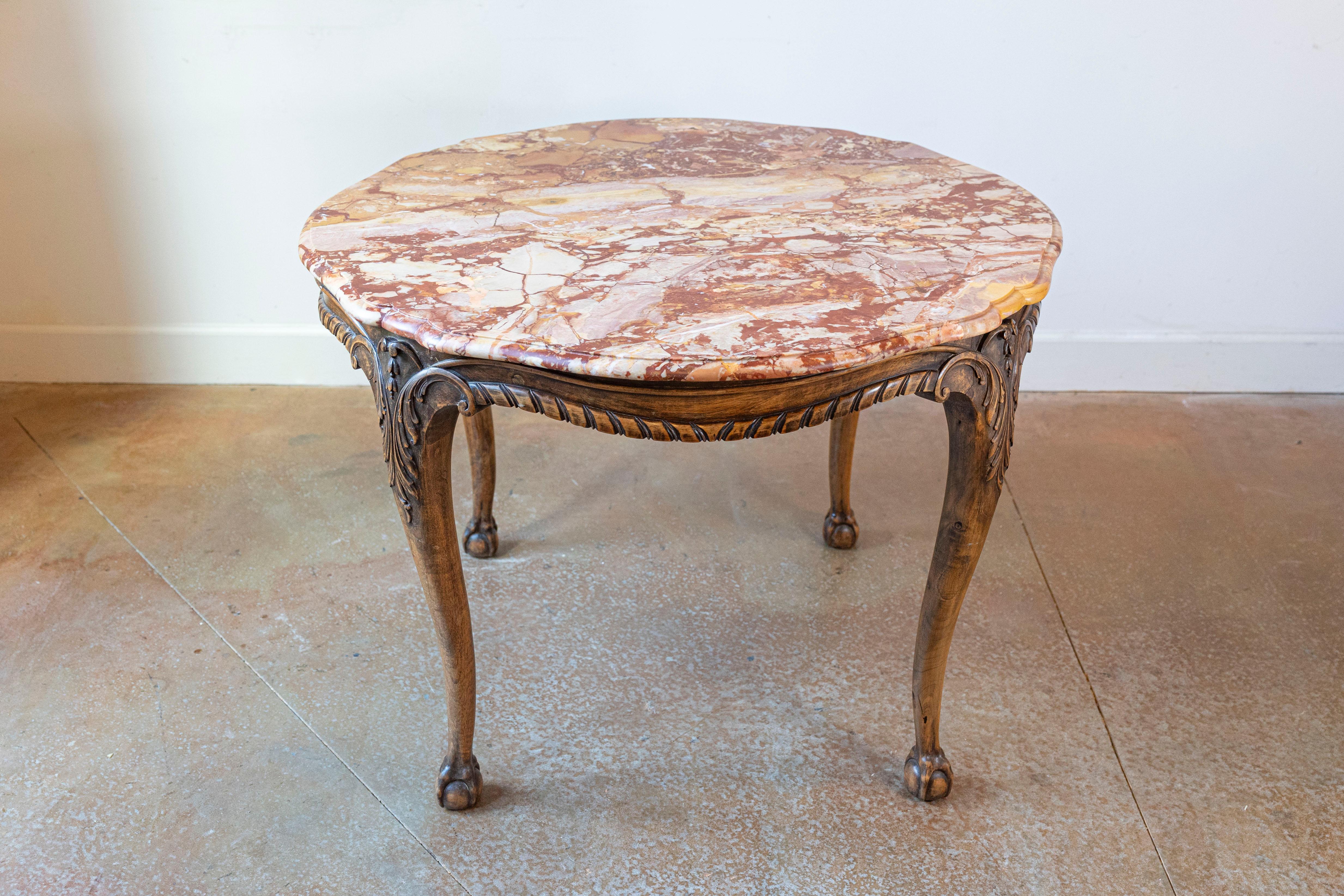 Table centrale française en noyer sculpté du XIXe siècle, avec un plateau en marbre panaché, une moulure en ruban torsadé et des pieds en forme de boule et de griffe. Cette exquise table centrale française est dotée d'un plateau circulaire en marbre
