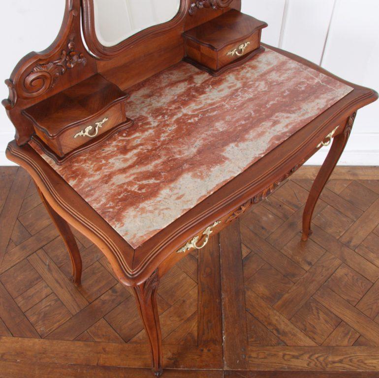 A lovely French, carved walnut, Louis XV-style vanity with one long drawer and two small upper drawers, and with an adjustable mirror with curved bevelled edges, circa 1900.

Measures: 38? wide x 22? deep x 57? tall (top of mirror) x 30? tall (to