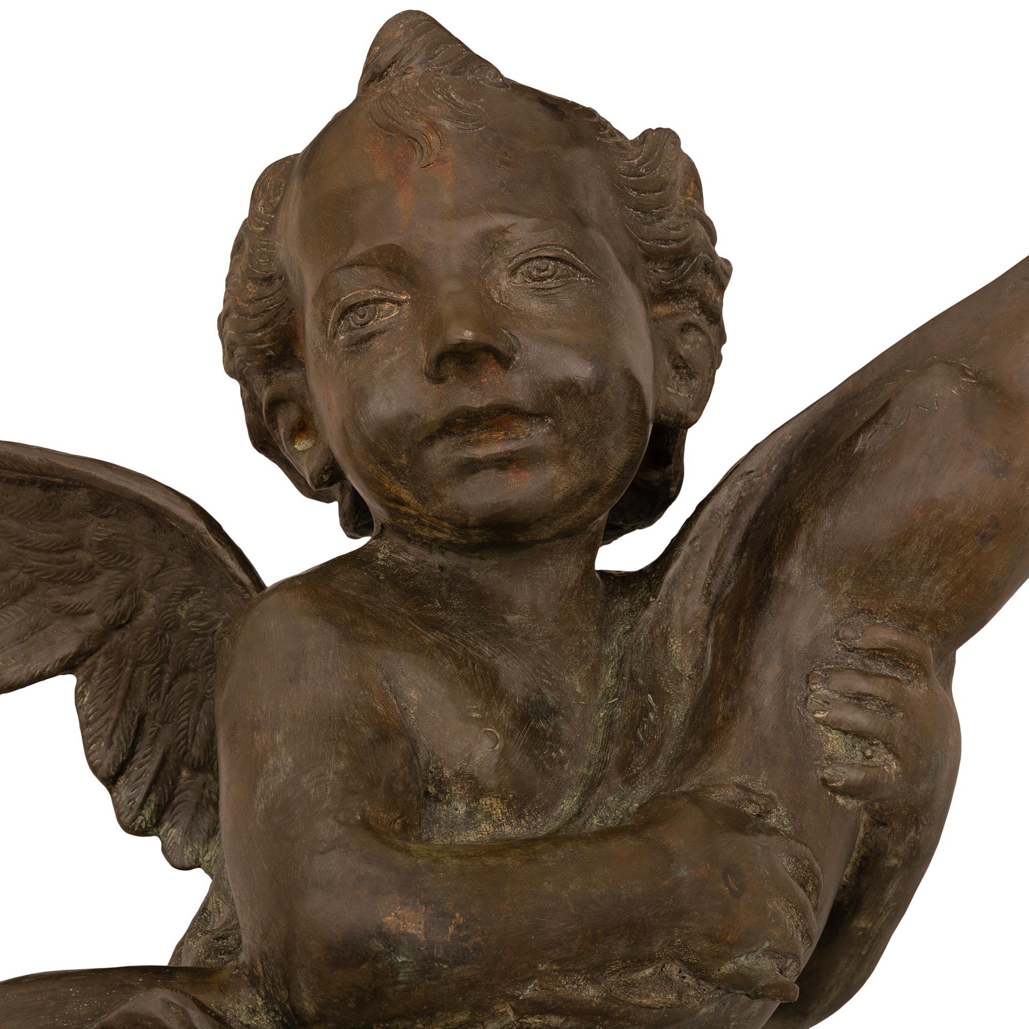 A beautiful and most charming French 19th century cast iron fountain of a young boy holding a dolphin. The fountain is raised on an octagonal base and an elegant dome shaped support. The charming young boy displays finely detailed wings on his back