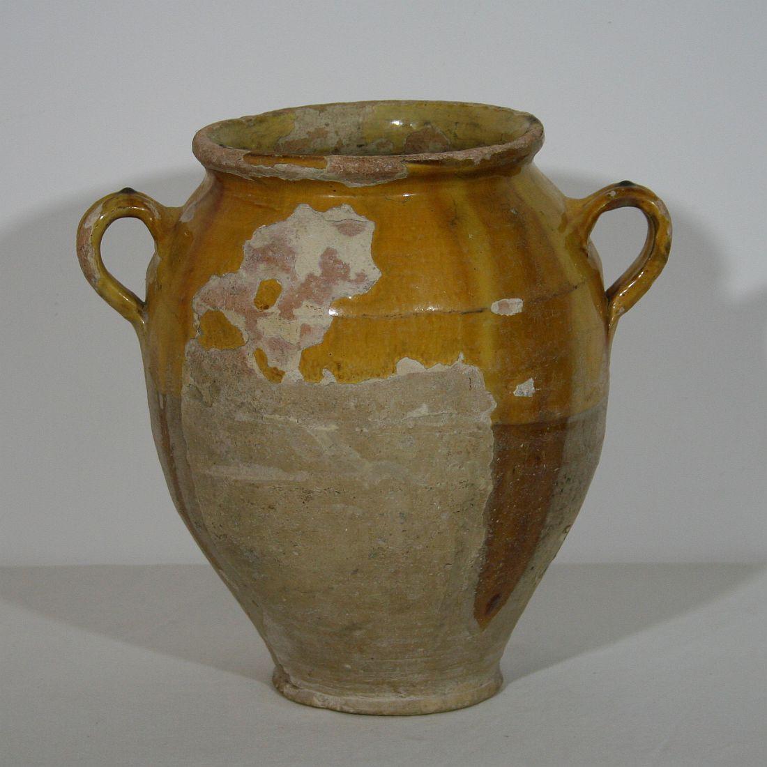 Beautiful weathered confit jar. Confit jars were used primarily in the South of France for the preservation of meats such as duck or goose for dishes such as cassoulet or foie gras.The bottom halves were left unglazed, due to the fact that the pots