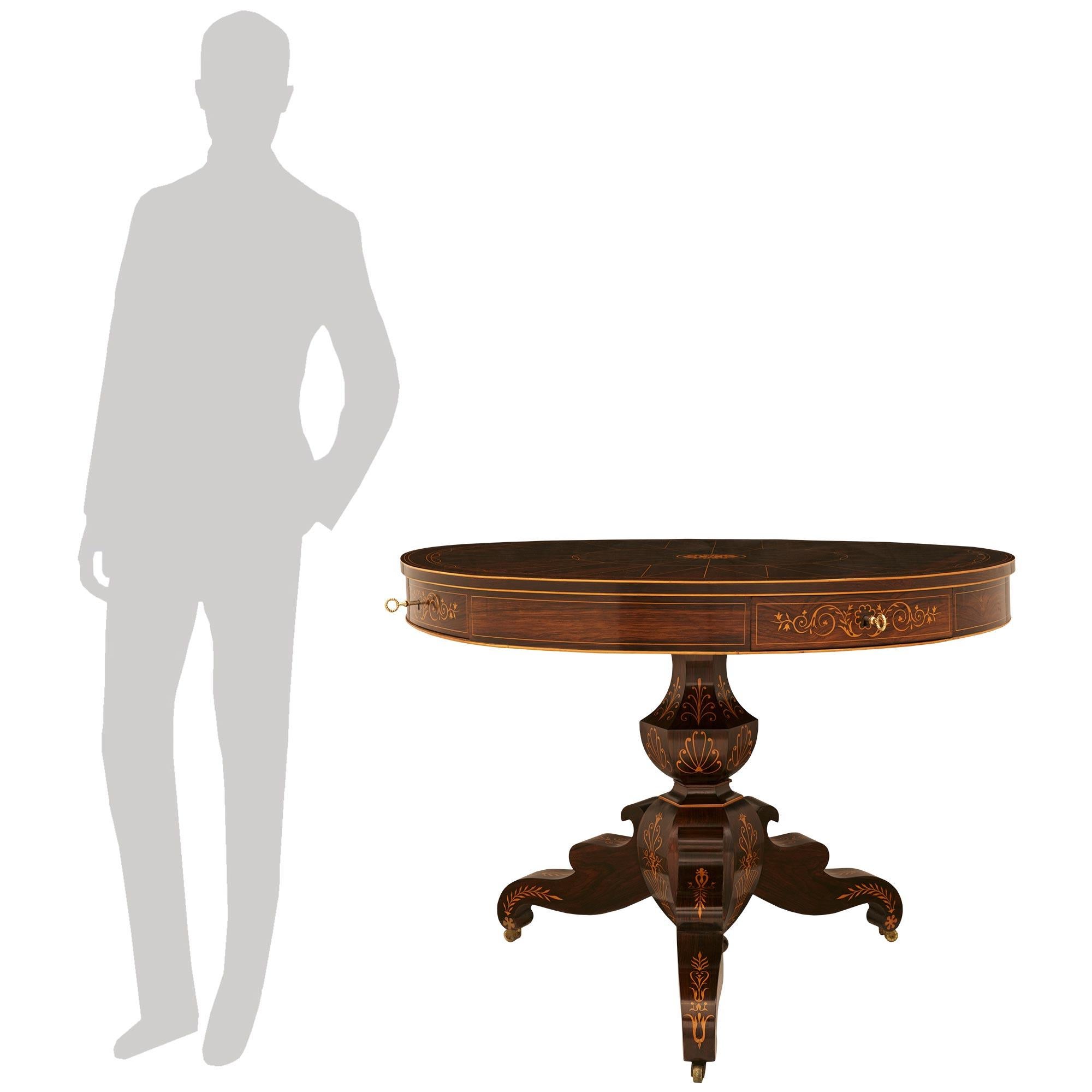 A high quality and most handsome French 19th century Charles X Period Mahogany, Rosewood, Maple and Brass center table. This most decorative table is supported on a tripod base with scrolled legs decorated by inlaid foliage and palmette designs,
