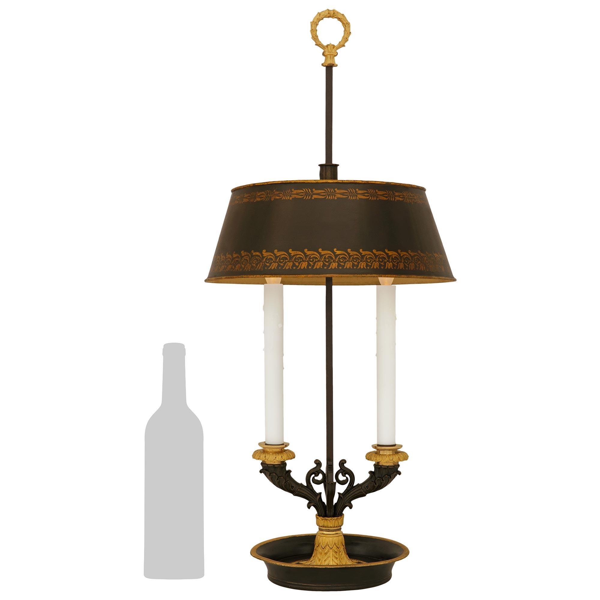 Elegante e di alta qualità lampada Bouillotte francese del XIX secolo del periodo Charles X in bronzo patinato, tole e ormolu. Questa splendida lampada a due bracci è sollevata da una base circolare in bronzo patinato e Ormolu con un bordo dorato e