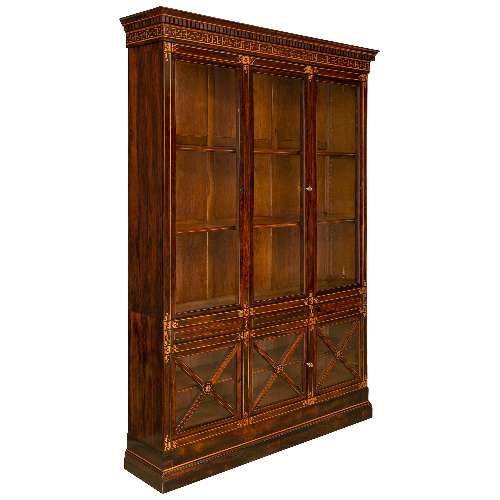 A handsome French 19th century Charles X period Rosewood and Maple bookcase/vitrine. The vitrine is raised on a mottled plinth below three square bottom glass doors displaying X designs with central rosettes and original lock surrounded by Greek key