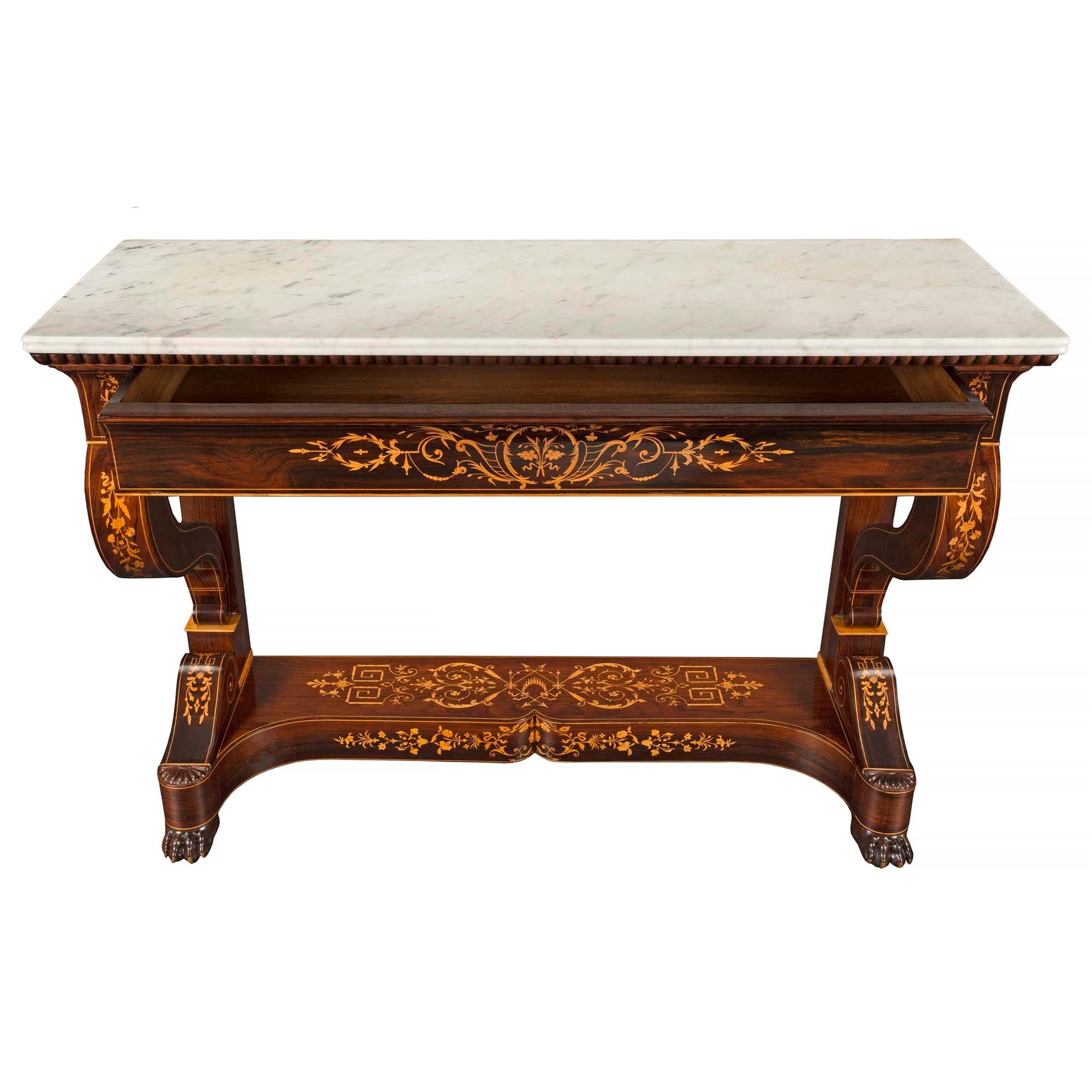 An outstanding French 19th century Charles X period rosewood, maple and marble console with one drawer. The console is raised by handsome carved paw feet below a most decorative concave, arbalest shaped bottom tier with beautiful masterfully inlaid