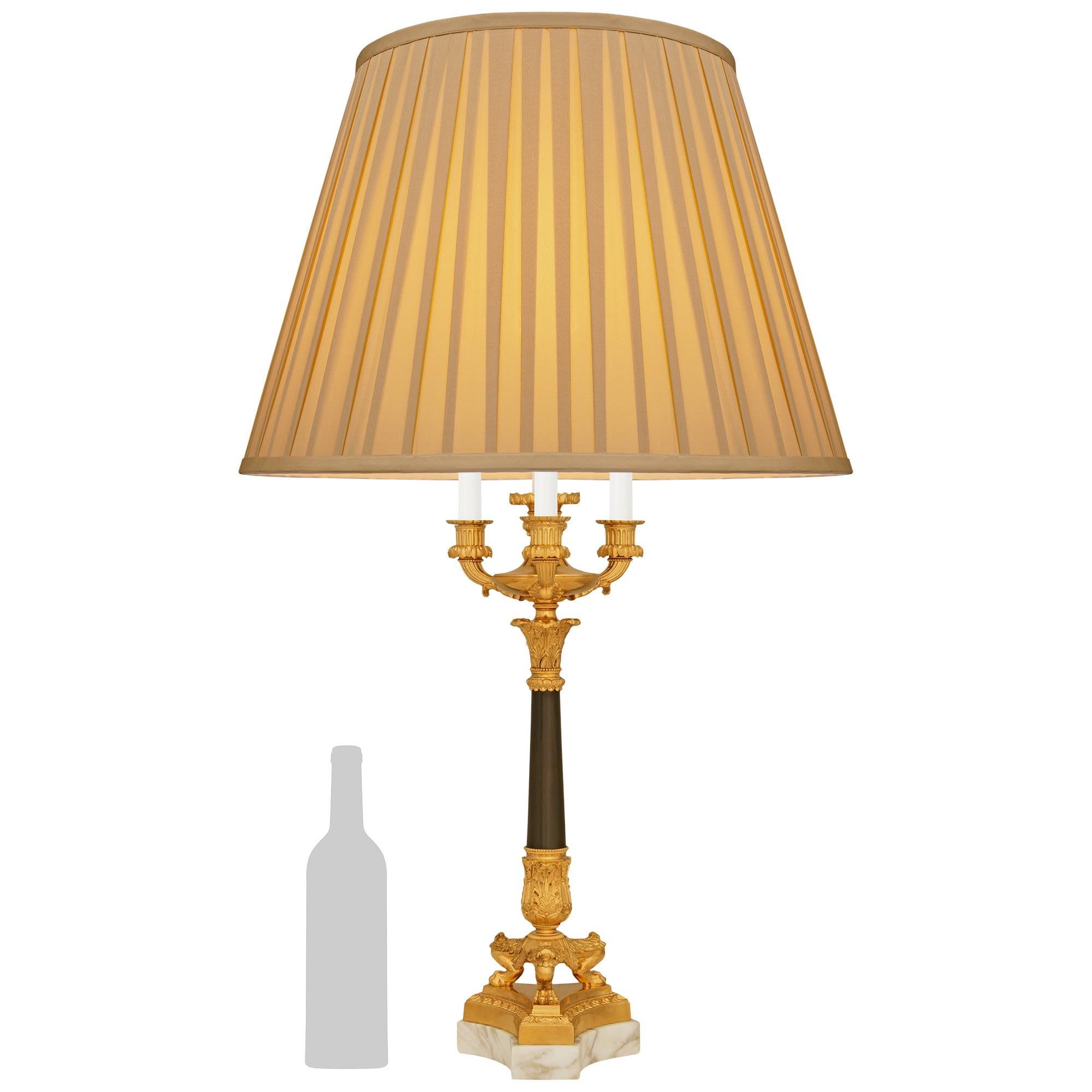 A stately and high quality French 19th century Charles X st. Calacatta marble, patinated Bronze and Ormolu lamp. This wonderful candelabra mounted into a lamp is raised on a triangular Calacatta marble base with concave sides. The Ormolu platform