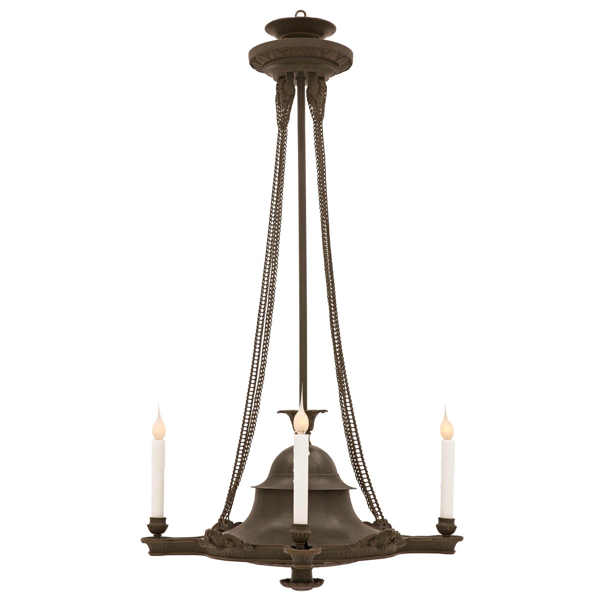 A handsome French early 19th century Charles X st. patinated bronze chandelier. The four light chandelier is centered by a charming richly chased reeded floral bottom finial below beautiful foliate designs and charming rosettes. The most decorative