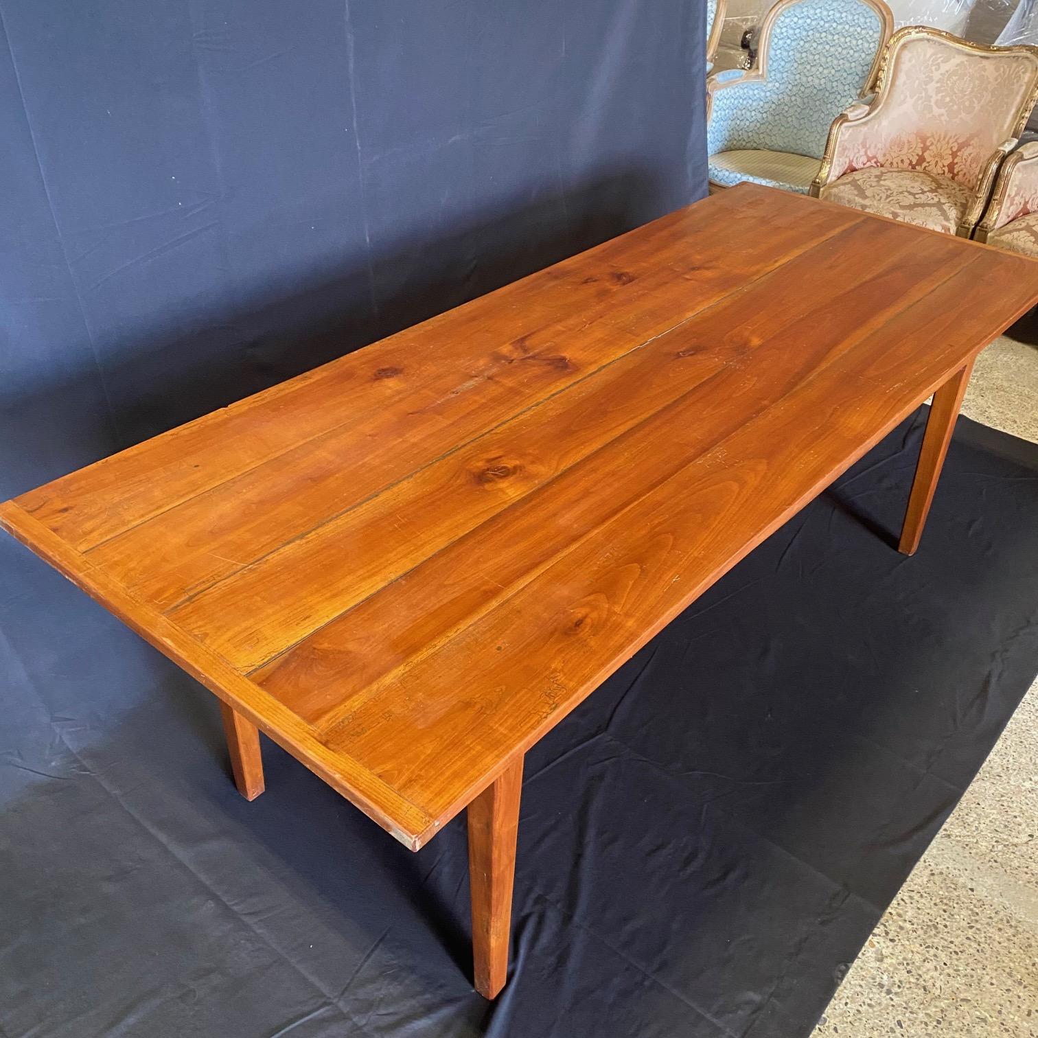 Cette table de ferme de style provincial français est fabriquée en bois de cerisier de haute qualité et présente un long plateau qui offre suffisamment d'espace pour les réunions de famille ou les dîners, le tout soutenu par d'élégants pieds