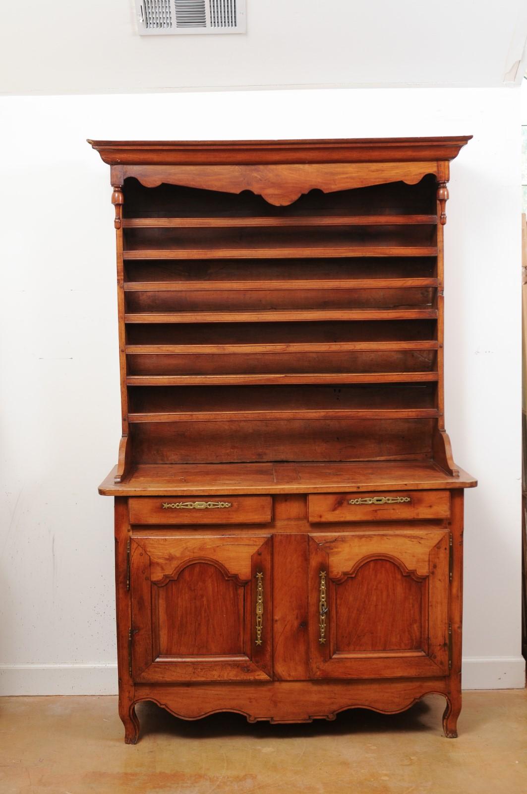 A French cherry vaisselier from the 19th century from the Charente region, with turned finials, plate shelves, drawers and doors. Created in Western France during the 19th century, this cherry charentaise vaisselier features a narrow upper section