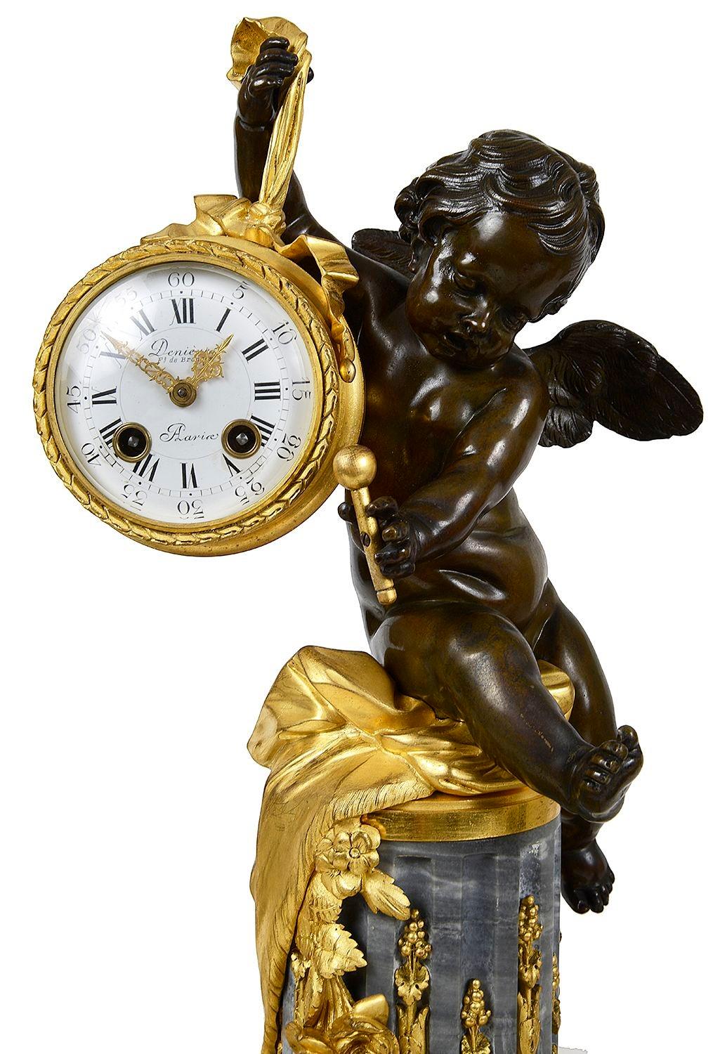 An enchanting and very good quality French 19th Century grey marble and gilded ormolu clock garniture, each piece with a patinated bronze cherub seated hold candle sticks either side and a clock hanging on a ribbon.
The white enamel clock face with