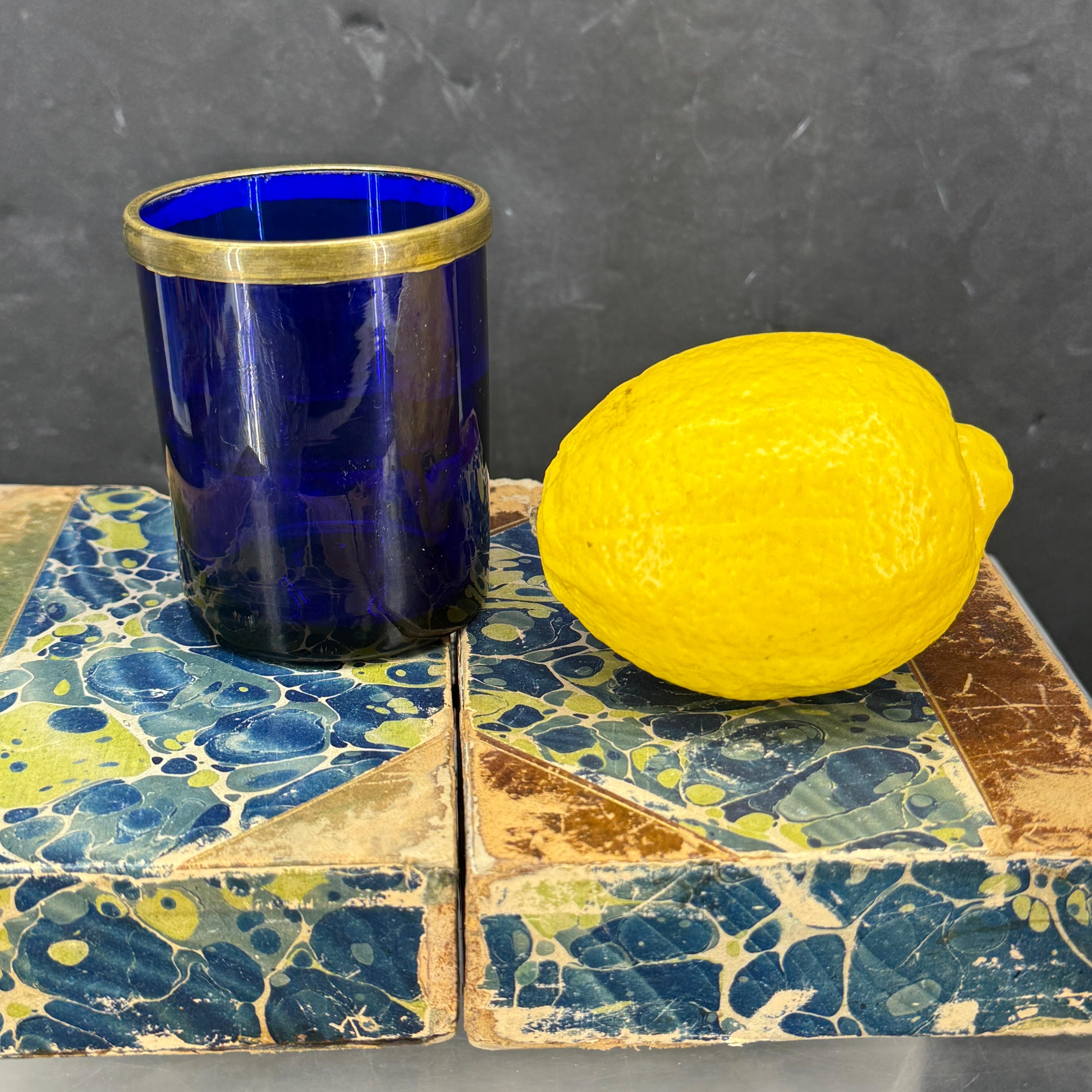 Tal como se encuentra en Dinamarca, un vaso muy versátil con borde de bronce. Vemos que esta pieza se utiliza como expositor, como copa de cóctel y como portaplumas. Estamos muy impresionados con el inmejorable desgaste vintage de la parte inferior.
