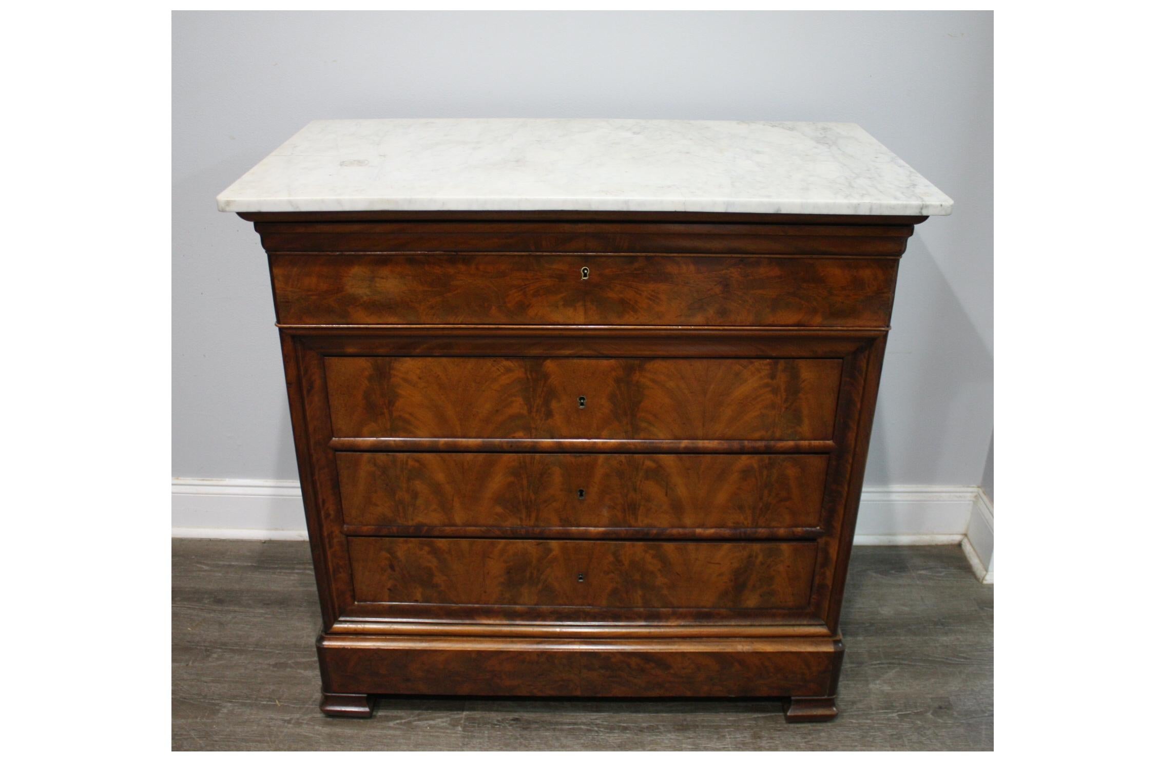 This Louis-Philippe Chest wears a beautiful white marble top with grey veins.
It is as well a desk with a wonderful burl wood and a light brown velvet fabric.