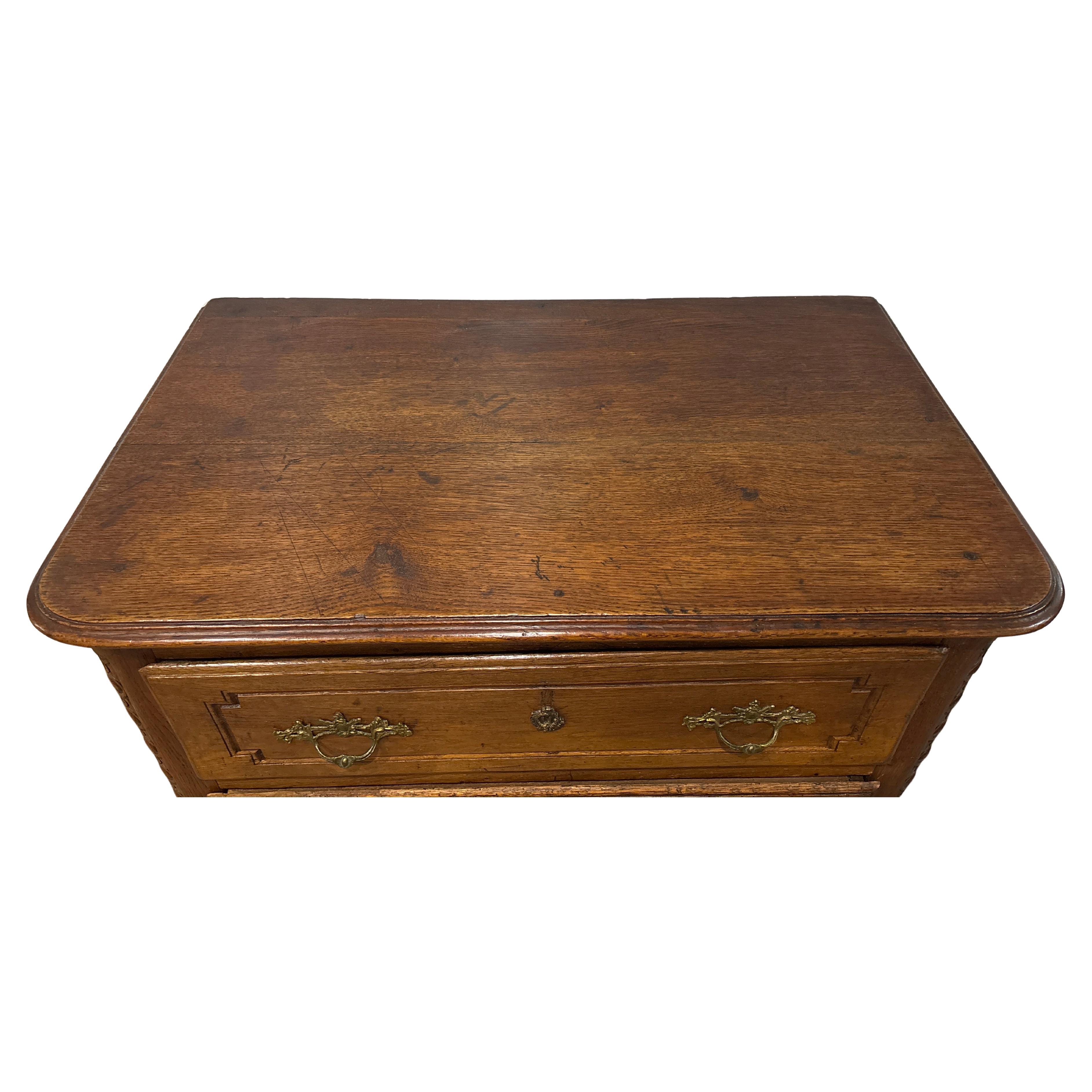 Esta encantadora cómoda es de roble con bonitos herrajes Luis XV. Está muy bien tallada por ambos lados.