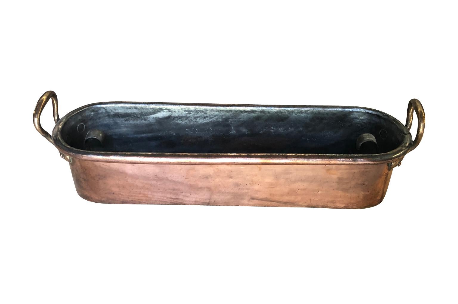 A mid-19th century fish pan in copper from the South of France. The pan retains its original poaching tray. Wonderful quality. A great addition to a copperware collection.
