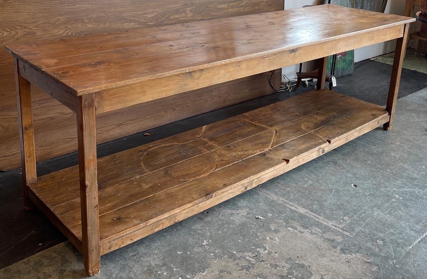 This is a 19th century counter from a store in France. It has a lower shelf for storage. We think this would make a great 8 foot dining table.