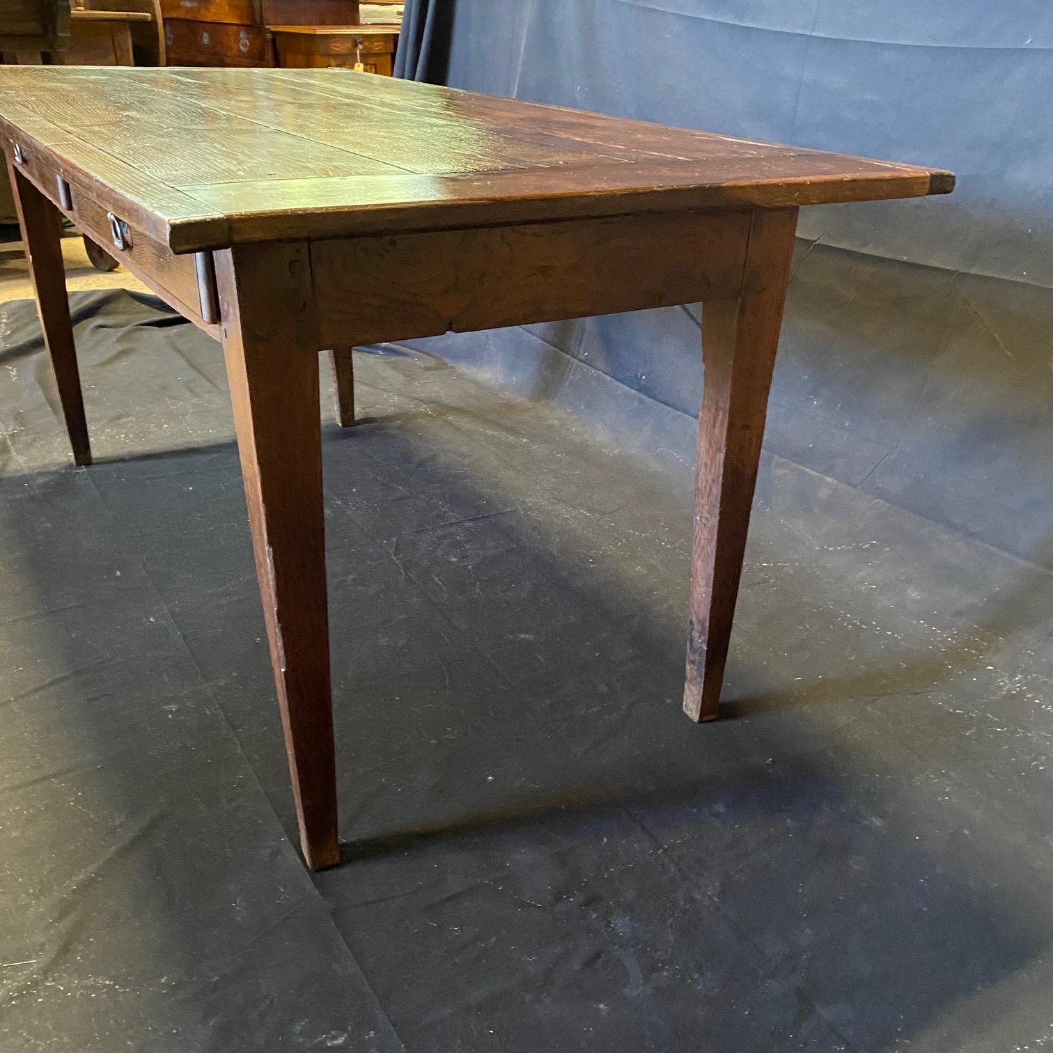 Lovely Provencal French oak dining table from the 19th century bought in the south of France. Beautiful patina and great flexible size. Two spacious drawers. Lovely tapered square carved legs means that chairs slide easily under the table. Perfect