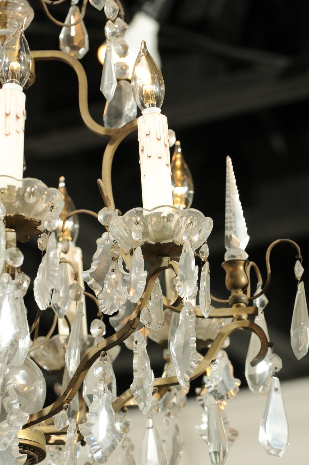 A French crystal and bronze six-light chandelier from the 19th century, with central crystal column and obelisks. Born in France during the politically dynamic 19th century, this exquisite six-light chandelier features a bronze armature, supporting