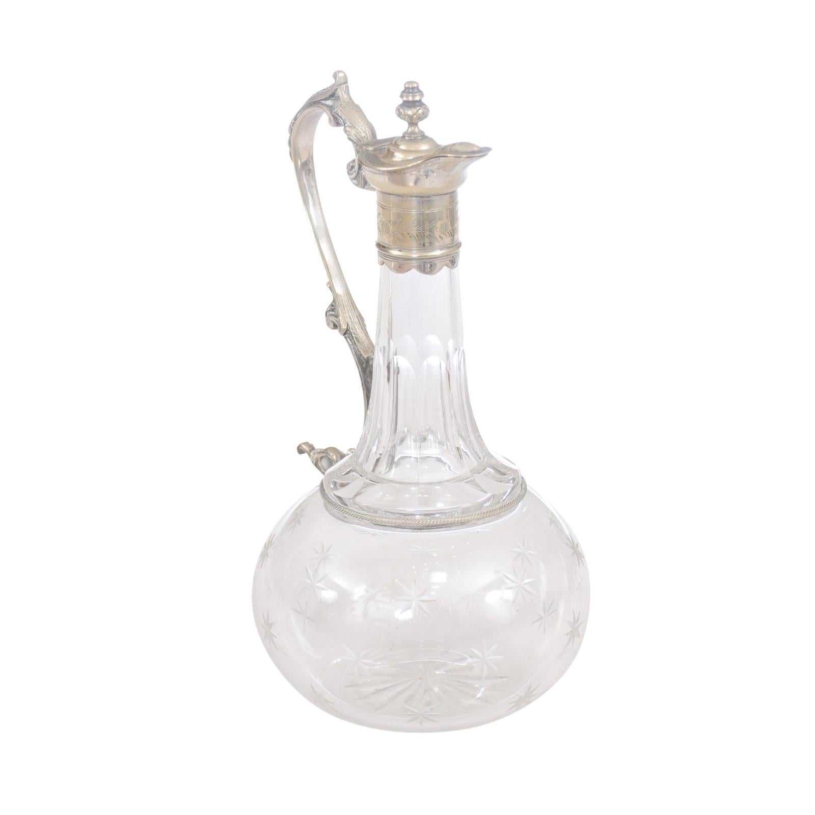 A French crystal wine decanter from the 19th century, with silver handle and top, and cut stars motifs on the body. A French crystal wine decanter from the 19th century, combining the brilliance of crystal with the opulence of silver, adorned with