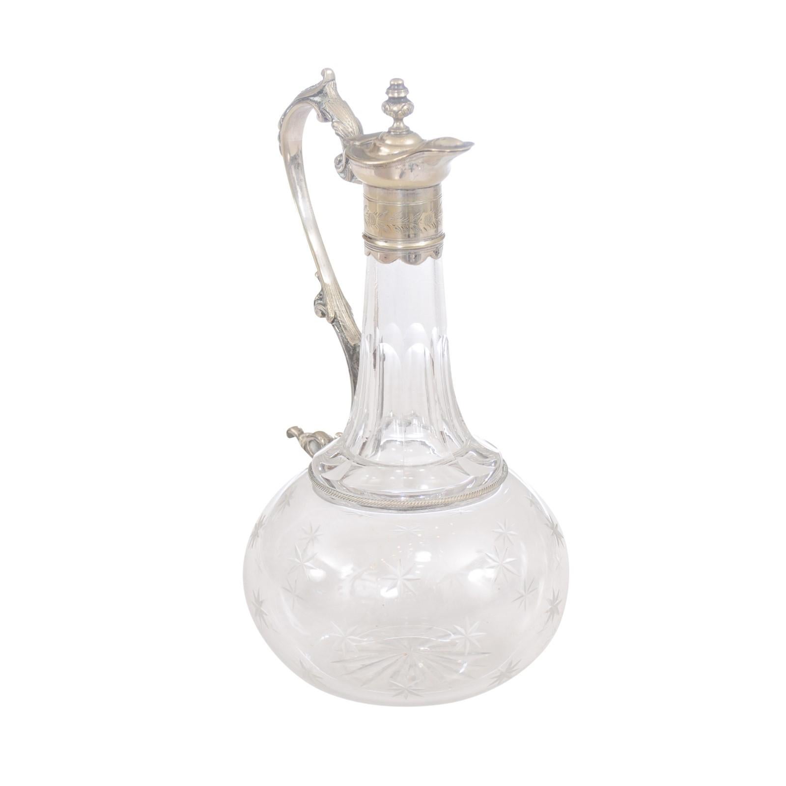 A French crystal wine decanter from the 19th century, with silver handle and top, and cut stars motifs on the body. A French crystal wine decanter from the 19th century, combining the brilliance of crystal with the opulence of silver, adorned with