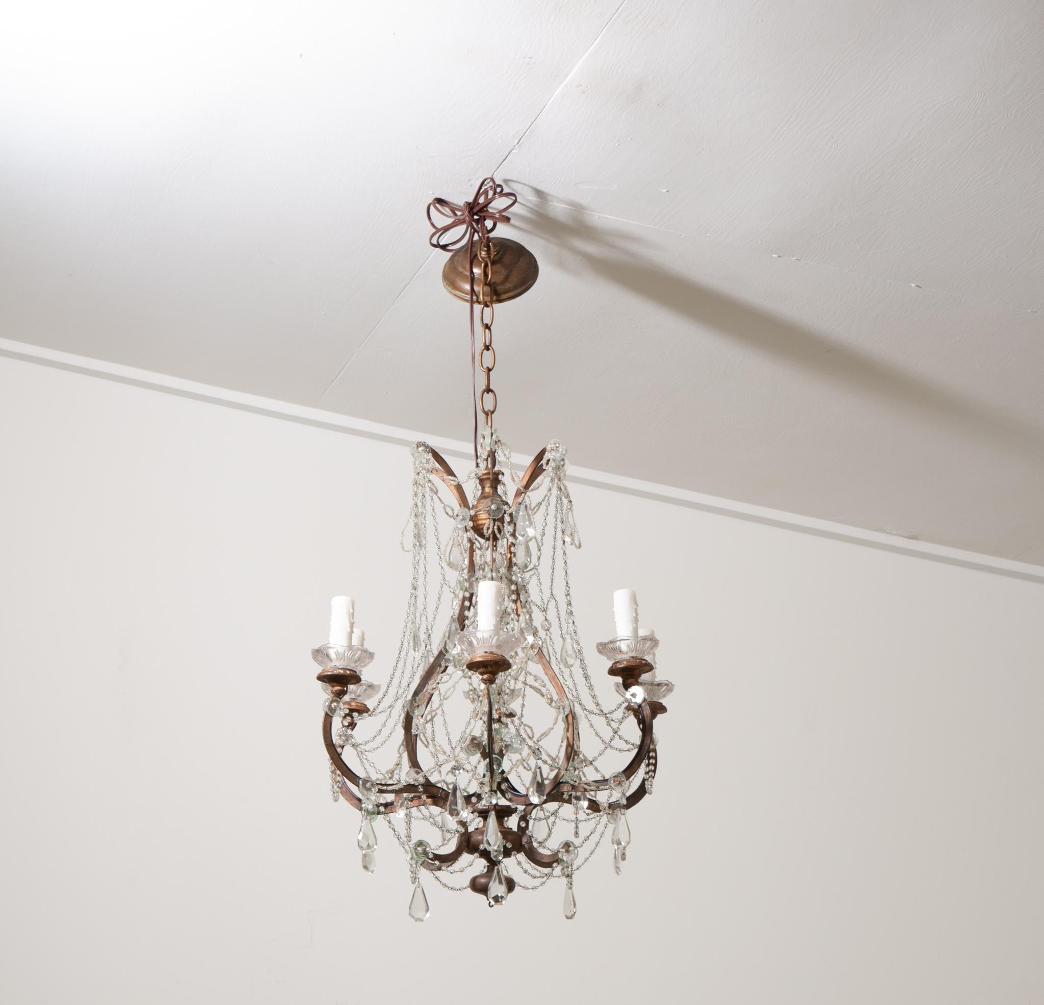 This French stunning 8 light chandelier is the perfect fixture for your interior. Hand cut crystal drops and crystal swags are found throughout the fixture and its perfectly patinated, heavy and quality bronze and carved giltwood frame.