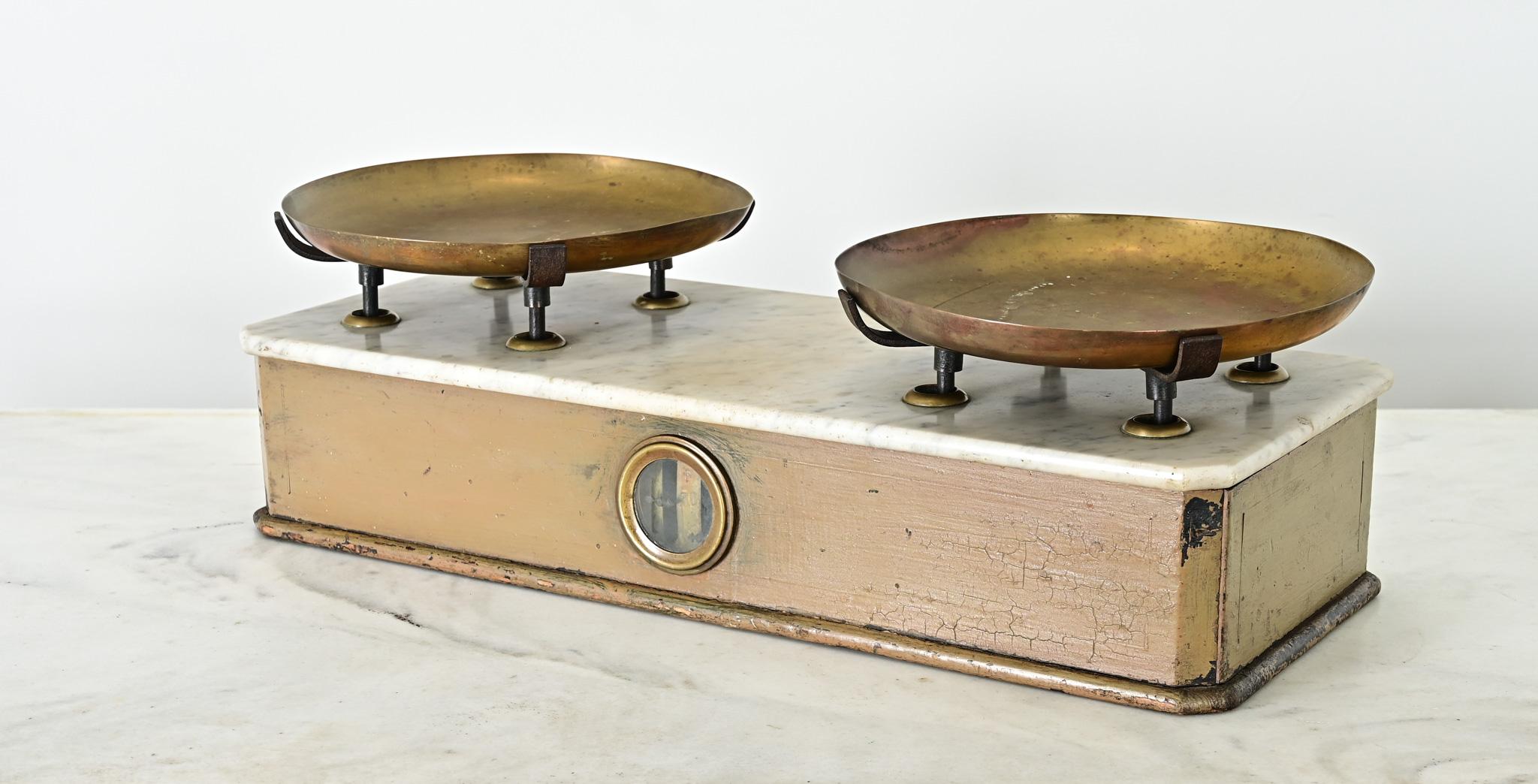 Balance de comptoir ou d'épicier française du 19e siècle avec deux plateaux en laiton montés sur un plateau en marbre blanc. Ce merveilleux instrument ancien était utilisé pour mesurer divers ingrédients et produits de nature épicurienne. Sur les