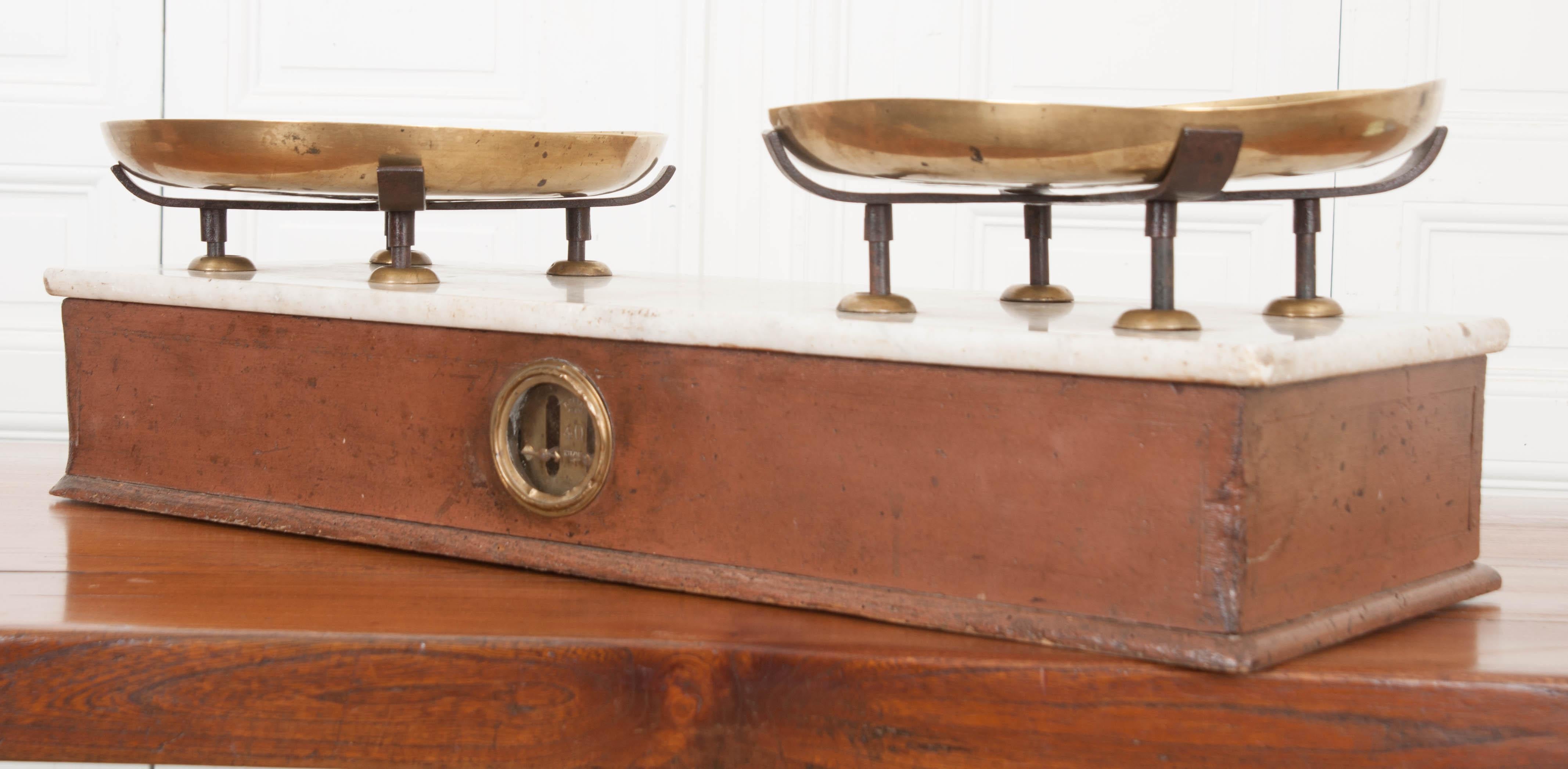 A large kitchen / culinary scale made in Lyon, France, circa 1880. This wonderful antique instrument was used to measure various ingredients and products that are epicurean in nature. Its sizable brass plates each contain a multitude of stamps that