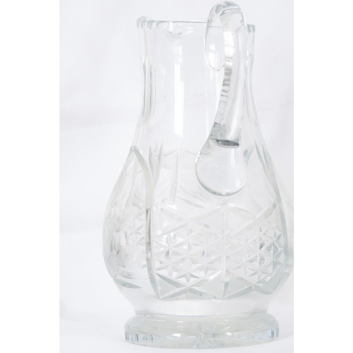 A fabulous, heavy crystal pitcher from late 19th century France. The vessel is ornamented with exceptional designs cut directly into the glass. Fluted details can be found around the neck, lip and handle, while floral etchings and cross hatching is