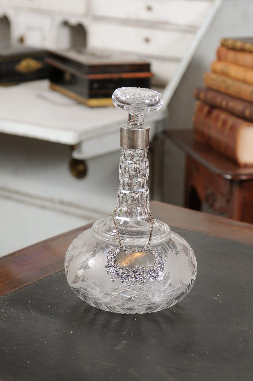 A French cut glass and silver decanter from the 19th century, with etched foliage and bird motifs. Created in France during the 19th century, this cut glass decanter is topped with a rosette shaped stopper sitting above a silver ring. Adorned with