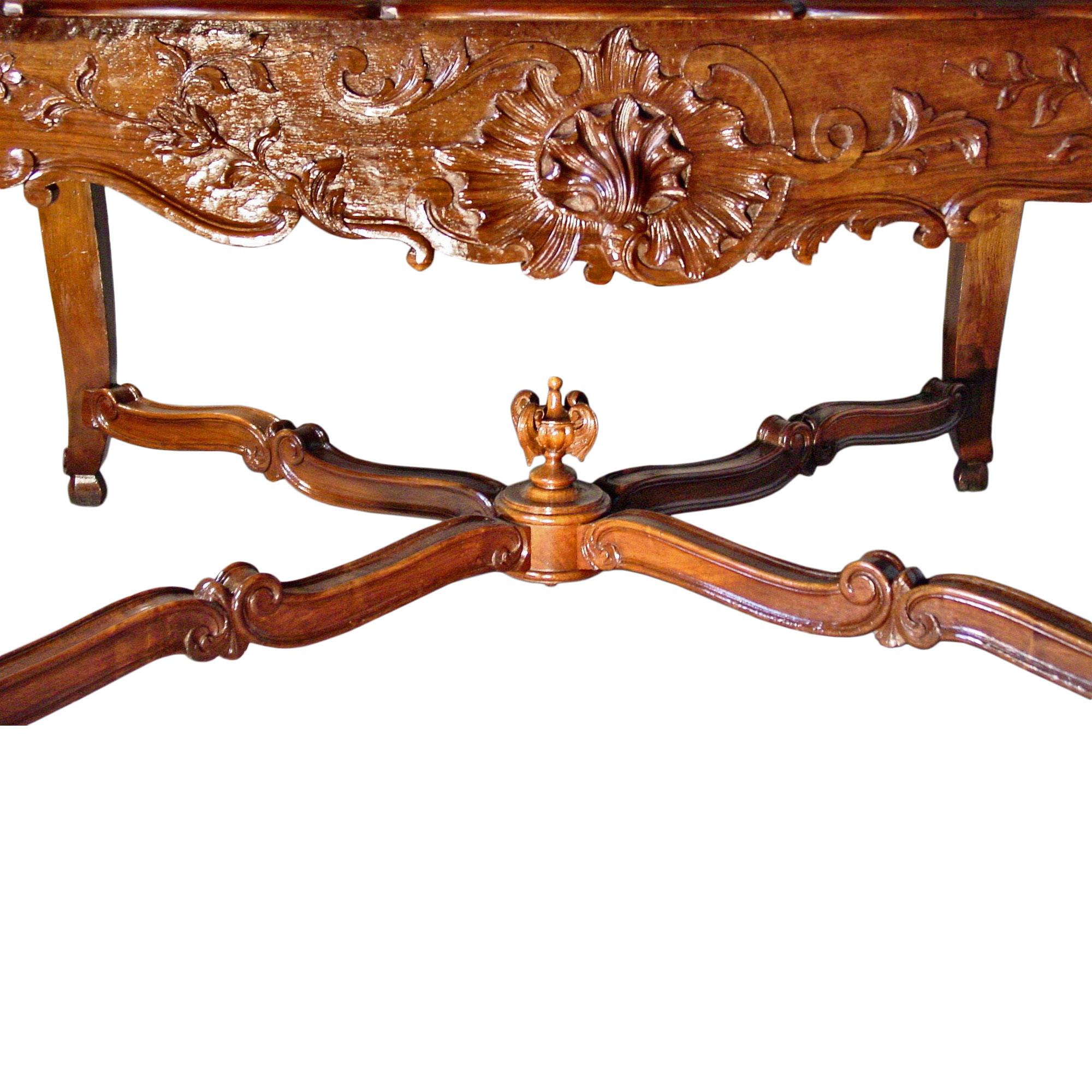A stunning and fine French 19th century dark oak center table with exquisite carvings of a central shell amidst another shell. On the sides is carved lattice work with flowers. The table raised on cabriole legs has carvings of acanthus leaves as
