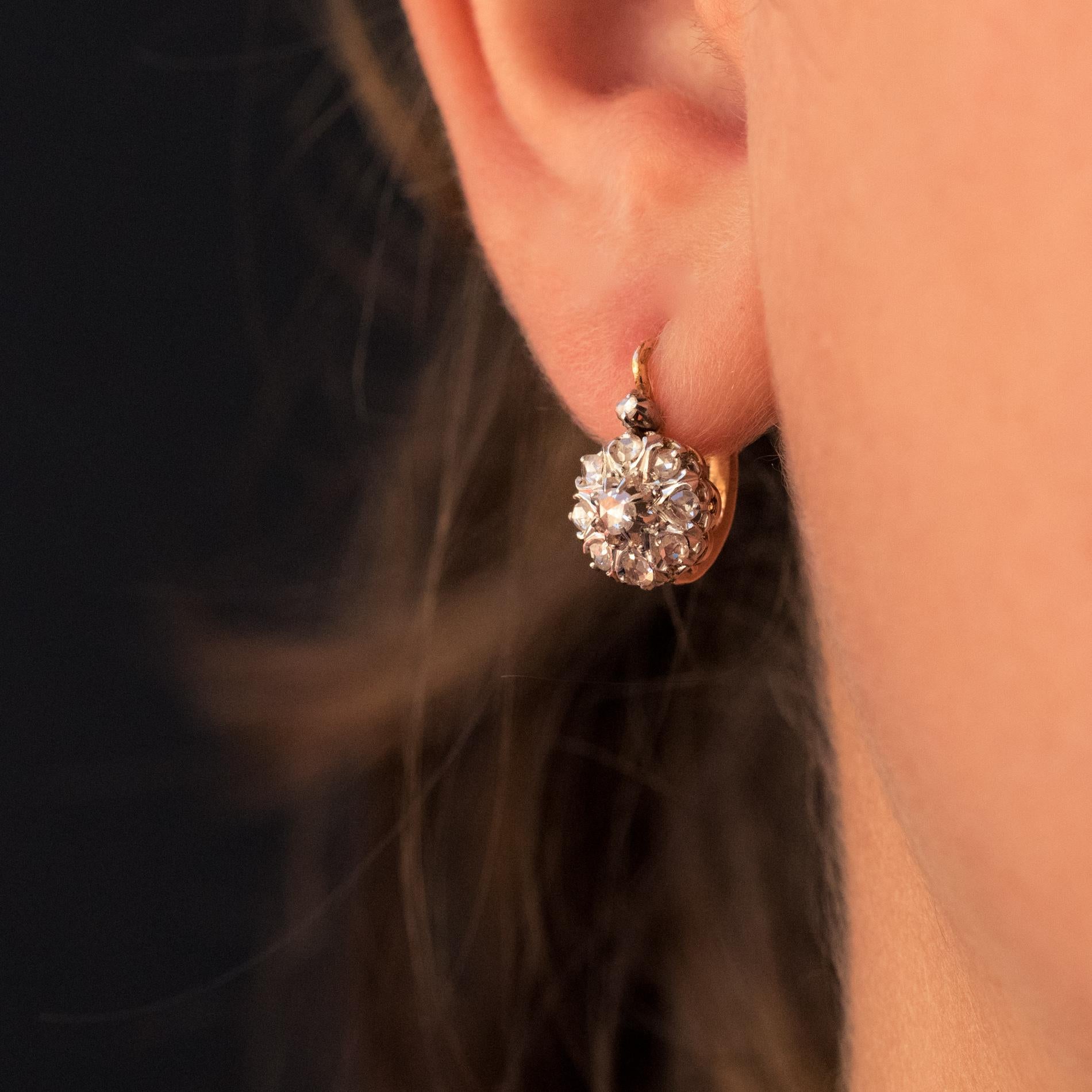 For pierced ears.
earrings in 18 karat rose gold, eagle's head hallmark and platinum.
With a daisy motif, each antique lever- back earring is set with rose-cut diamonds and is topped with another small rose-cut diamond. The attachment system is from