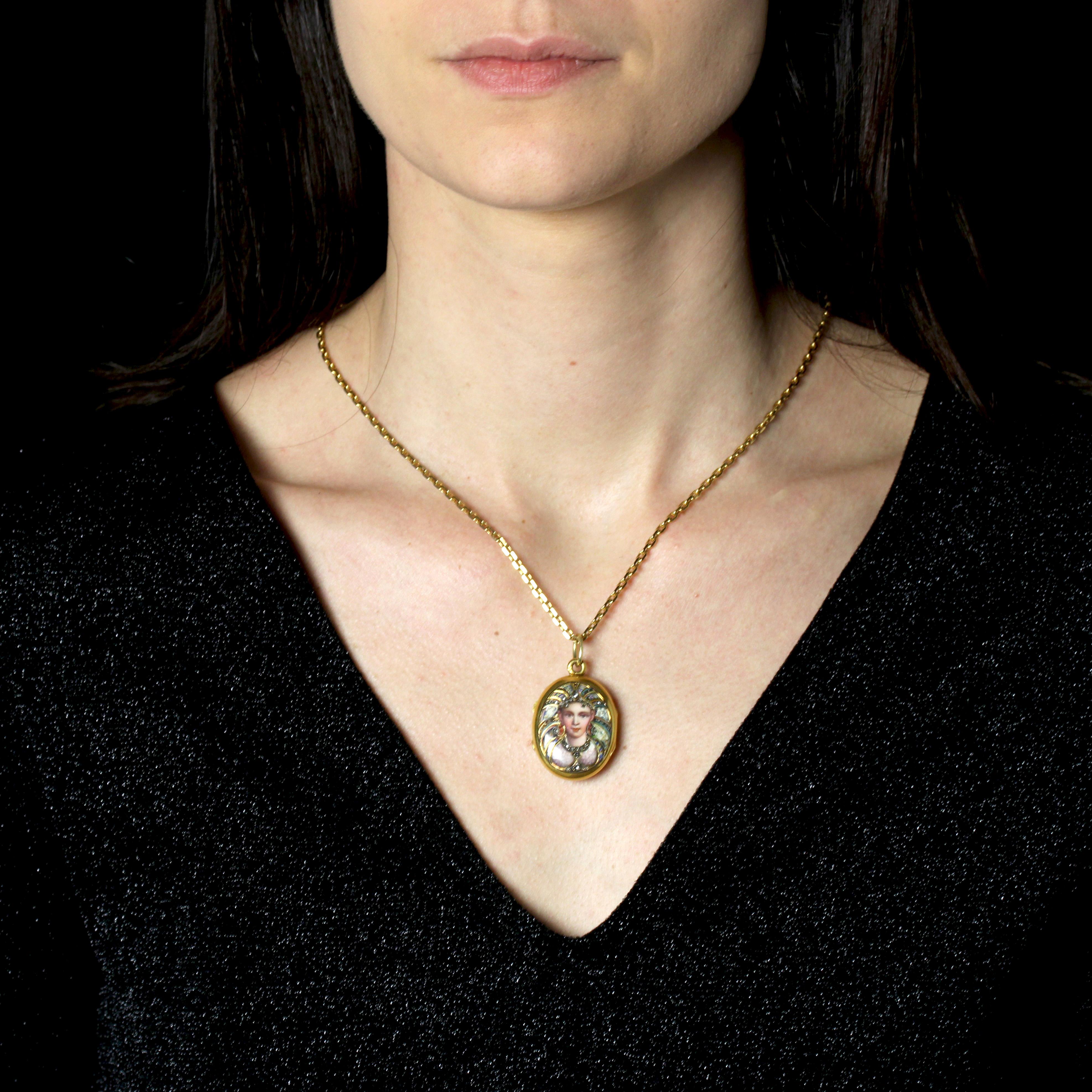 Locket pendant in 18 karat yellow gold, eagle head hallmark.
A collector's item, this opening antique pendant is oval in shape and adorned on the front with an enameled motif depicting a young woman in a setting and dress set with rose-cut diamonds.