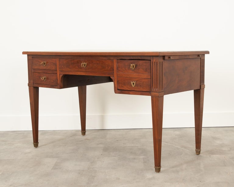 A handsome Directoire desk from 19th century France. Made from beautiful mahogany, cleaned and polished to reveal the vibrant grain. The top is inset with the original green leather, detailed with gold tooling around the perimeter and center. A