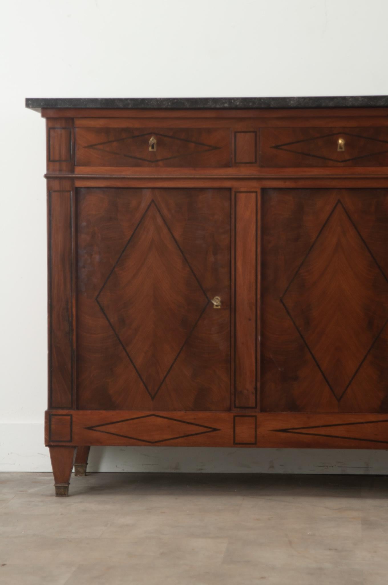 A Handsome Directoire mahogany and marble enfilade from France. You’ll find many fossils in the black marble top making for a gorgeous and durable surface. Below the marble is a bank of four drawers all with functioning locks. This case piece is