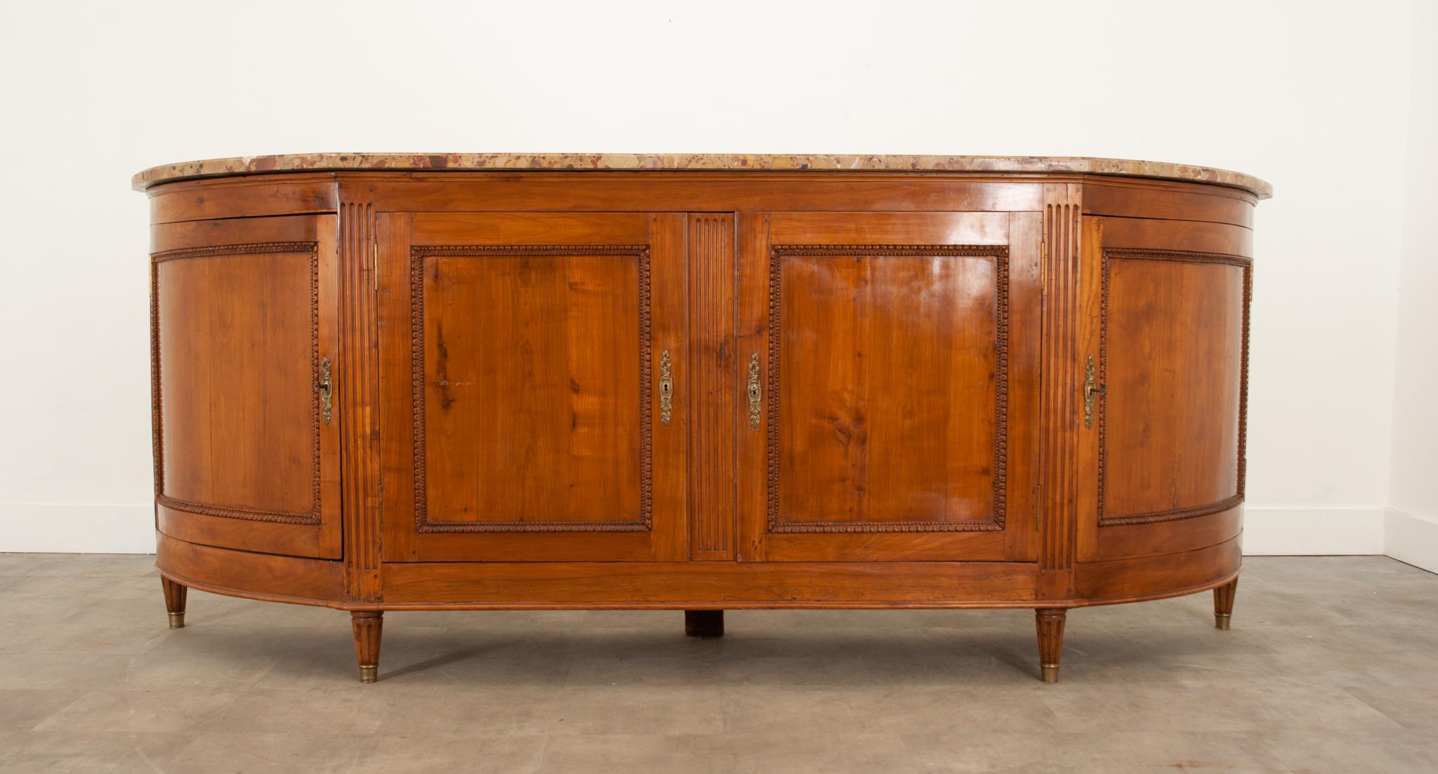 This Directoire enfilade is a great way to add more storage to any space. Topped with its original, shaped stone top that has been professionally repaired in two places- though it’s difficult to tell due to the movement of the stone. All four lower