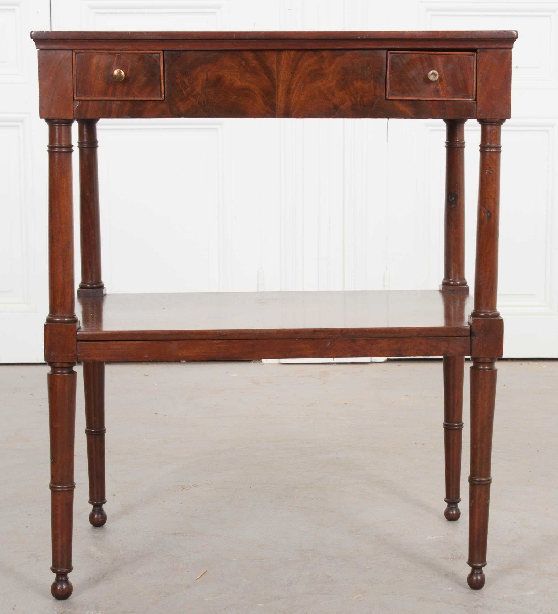 French 19th century Directoire-style mahogany occasional table, with grey-veined white marble top above an apron fitted with two small drawers over an under-shelf, and raised on tapering notched legs with ball feet.