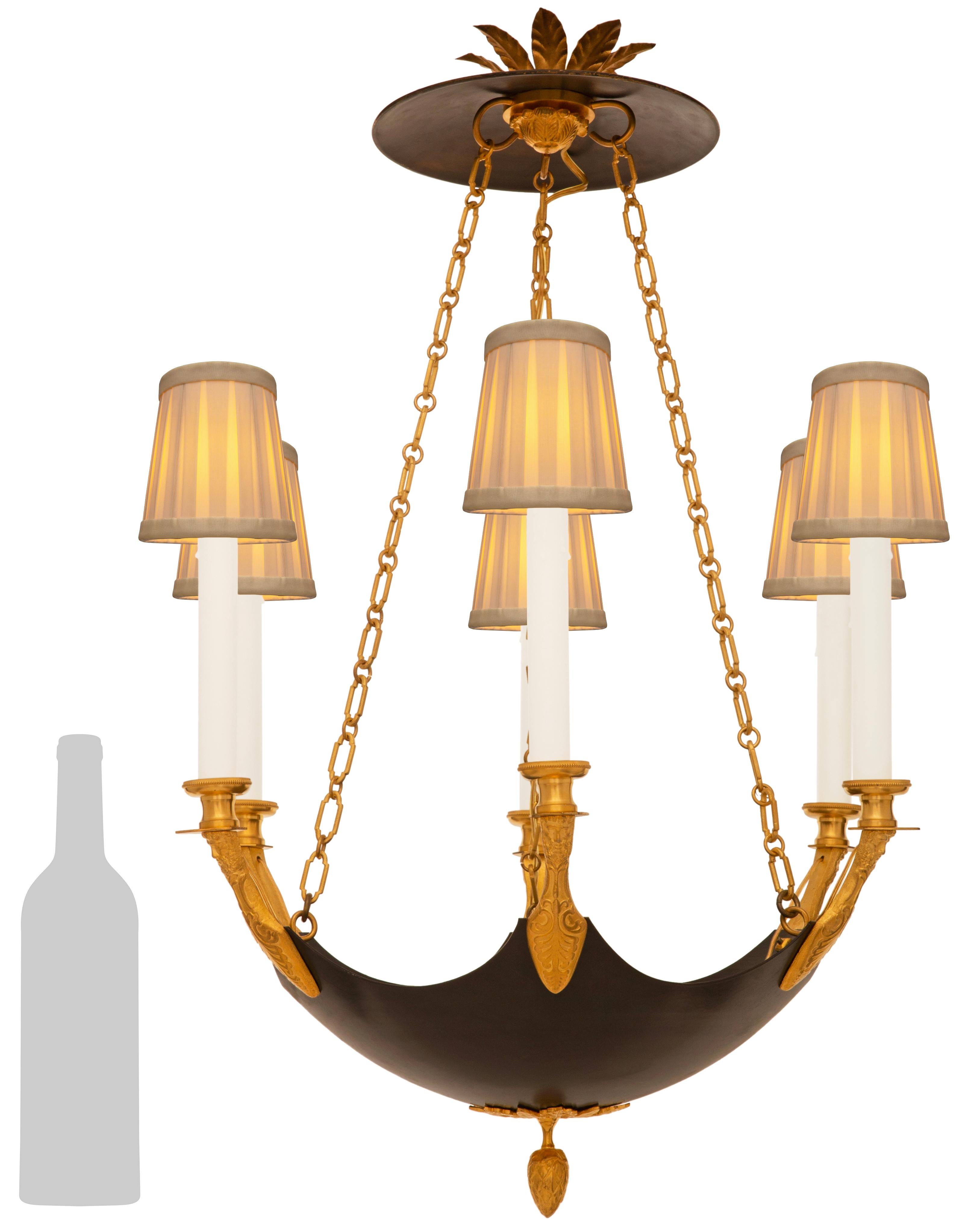 Un elegante e decoratissimo lampadario francese del XIX secolo in bronzo patinato e Ormolu. Questo bellissimo lampadario a sei bracci è centrato da un terminale inferiore a ghianda in Ormolu sotto una riserva di palmette in Ormolu traforate. Il