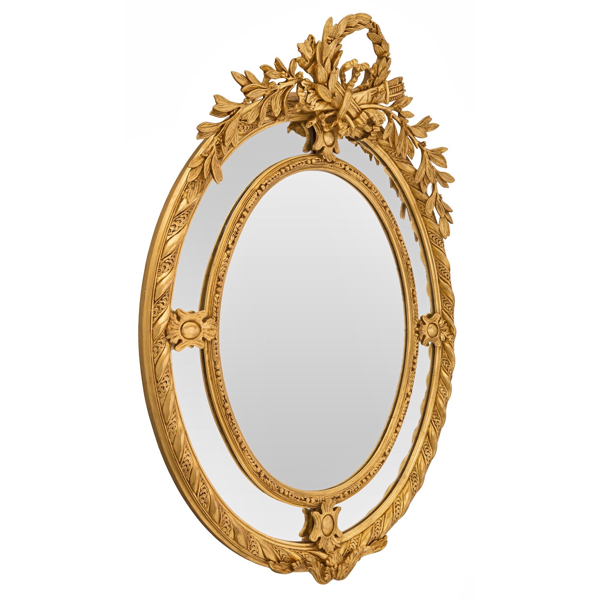 An exceptional and most elegant French 19th century double framed giltwood mirror. The oval mirror retains all of its original mirror plates throughout. The central mirror plate is set within a lovely finely detailed foliate and beaded border while