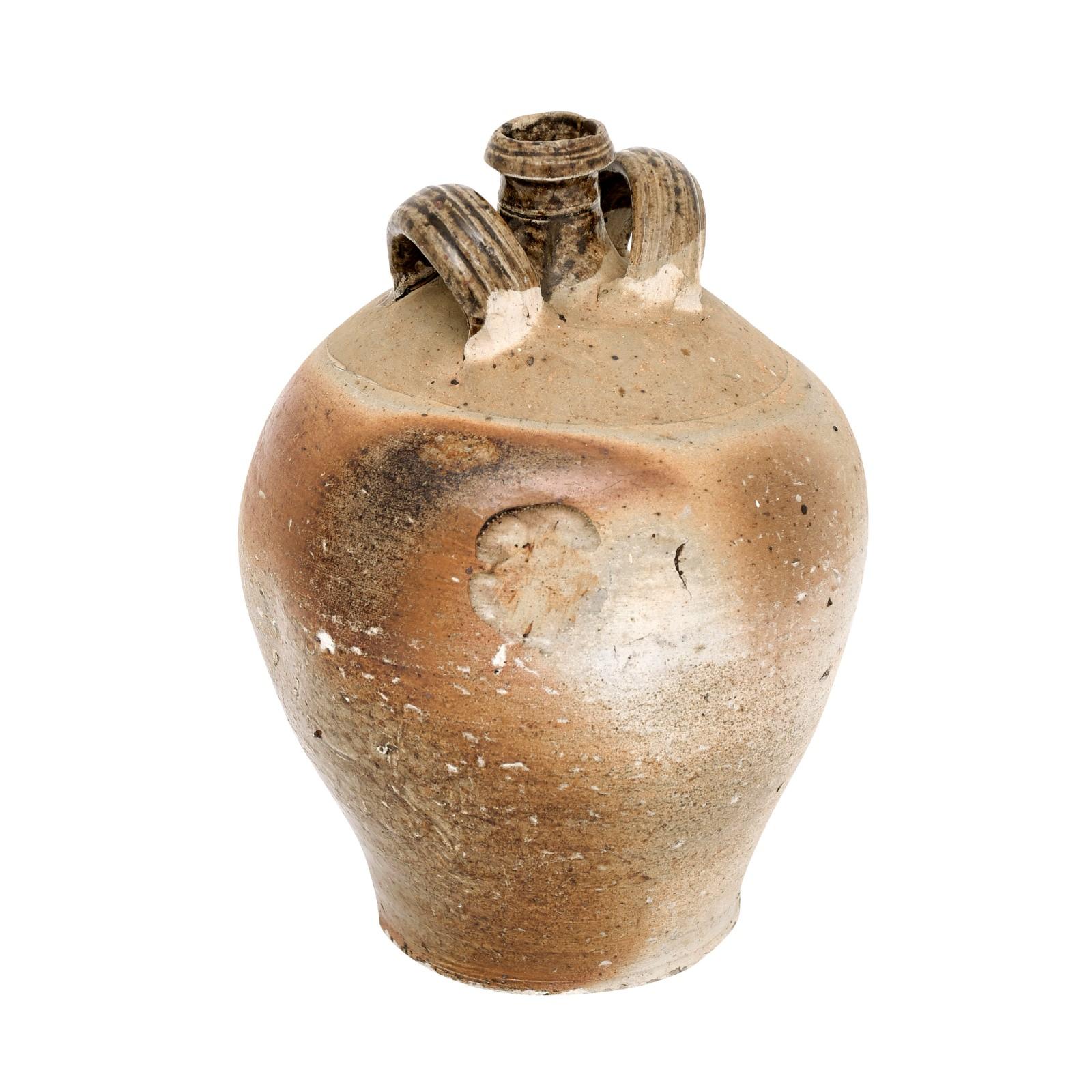 A French rustic double handled jug from the 19th century, possibly from Normandy. Indulge in the charm of French pastoral life with this rustic double-handled jug hailing from the 19th century, likely originating from the heartland of Normandy. This