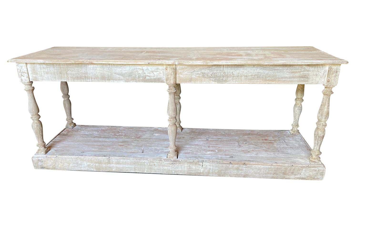 A very charming 19th century Draper's Table from the Provence region of France.  Soundly constructed from scraped pine with nicely turned legs and a lower shelf.  A wonderful console table or narrow kitchen island.