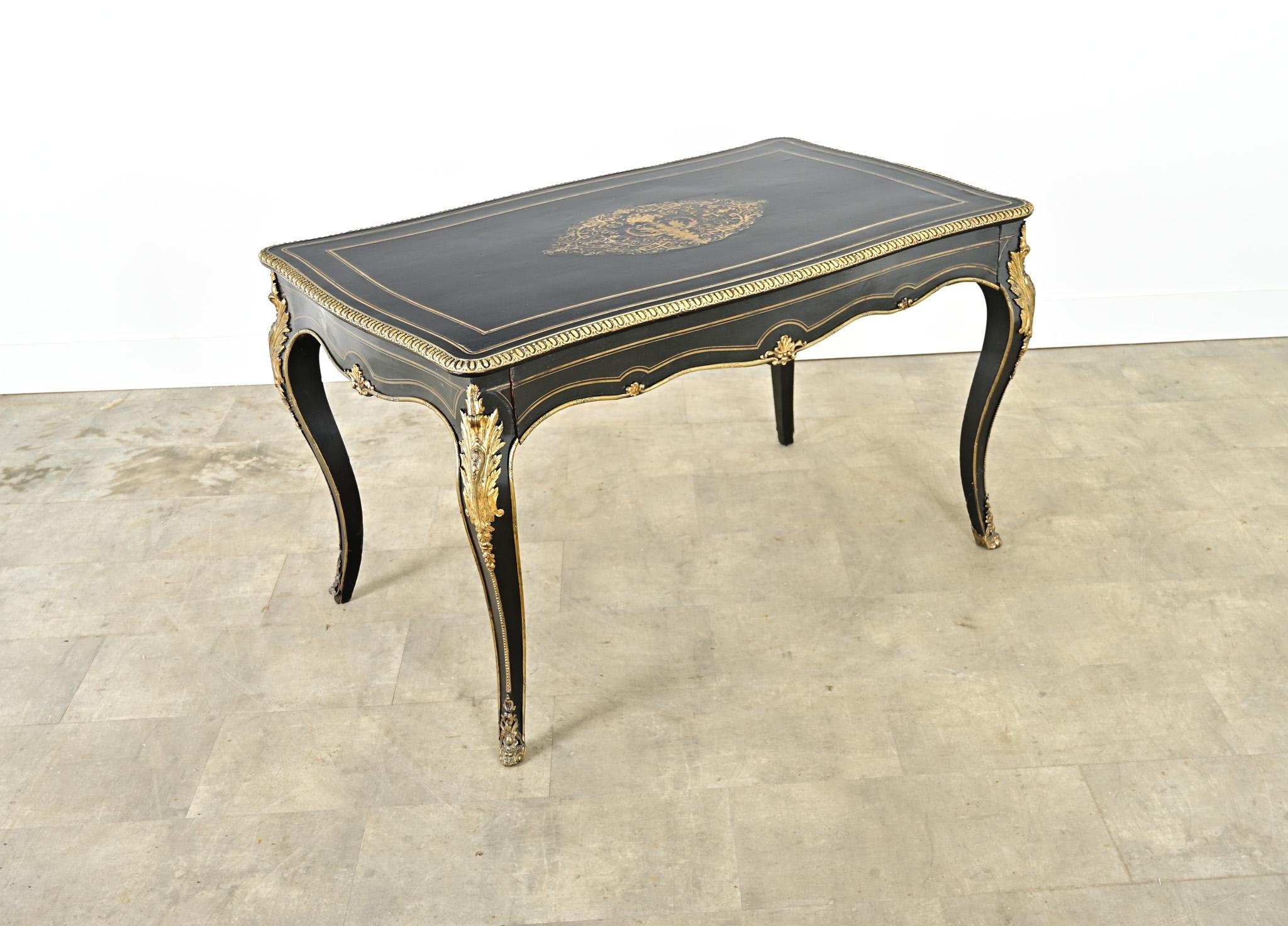 Deslumbrante escritorio de estilo Luis XV, ebonizado y con incrustaciones de latón, procedente de la Francia del siglo XIX, es una obra maestra de sensualidad rococó y atrevido gusto imperio. Esta exquisita mesa antigua puede desempeñar múltiples