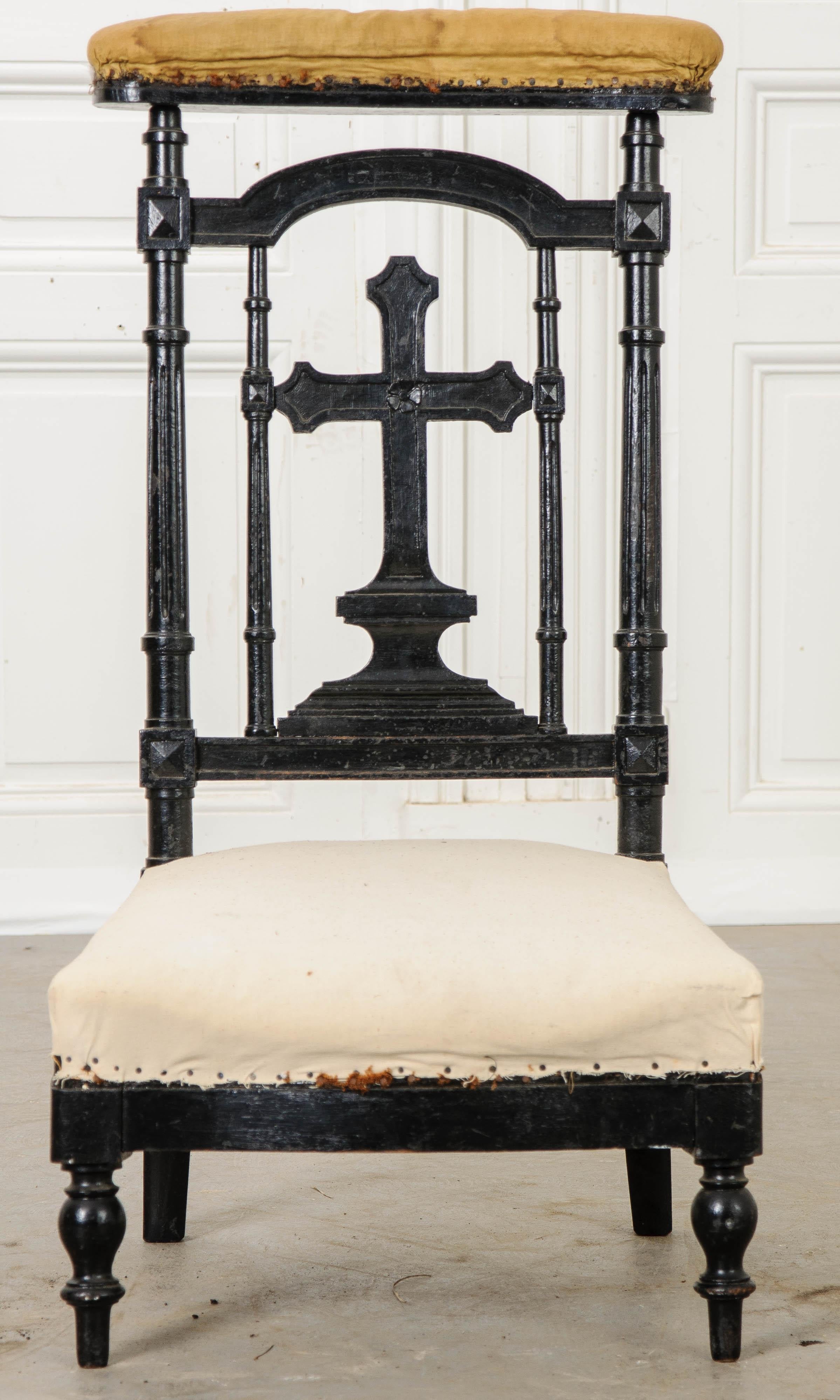 A delightful 19th century French prie dieu. The frame is made of hardwood that has been ebonized. This exceptional finish has become patinated over the decades, exposing some of the hardwood beneath. A beautiful carved cross can be found below the