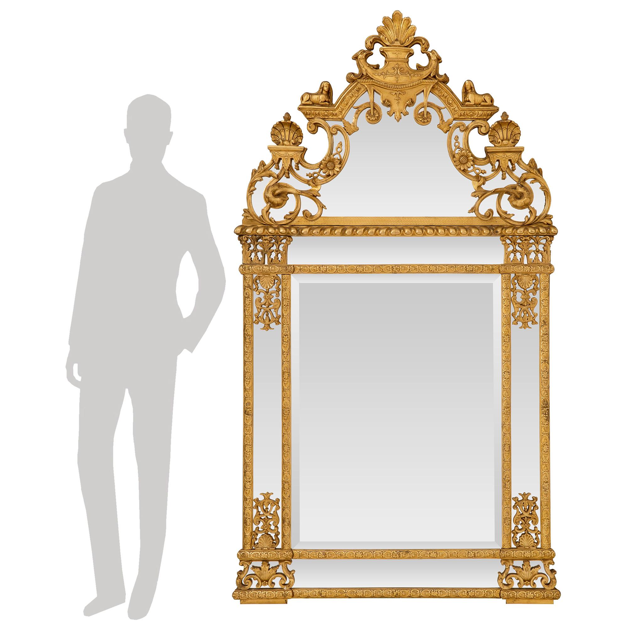 A stunning French 19th century Egyptian revival Neo-Classical st. giltwood double framed mirror. The original beveled mirror plate is framed within a finely carved foliate border. At the base and borders are additional original mirror plates also
