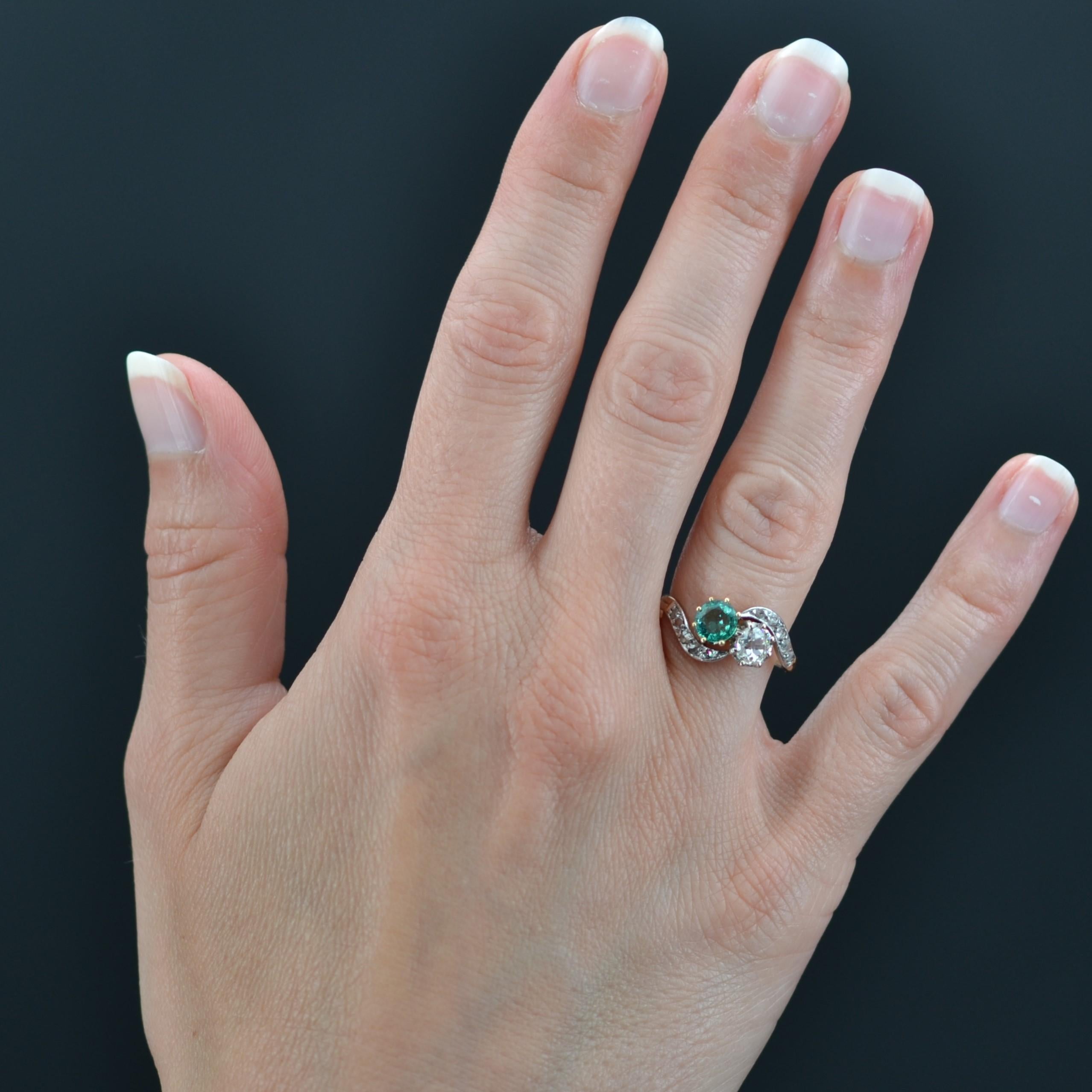 Ring in 18 karat yellow gold, and platinum.
Charming antique wedding ring, it is adorned on the top of a you and me formed by an antique cushion- cut diamond, and a round emerald water mint color. On either side, the start of the ring is formed by a