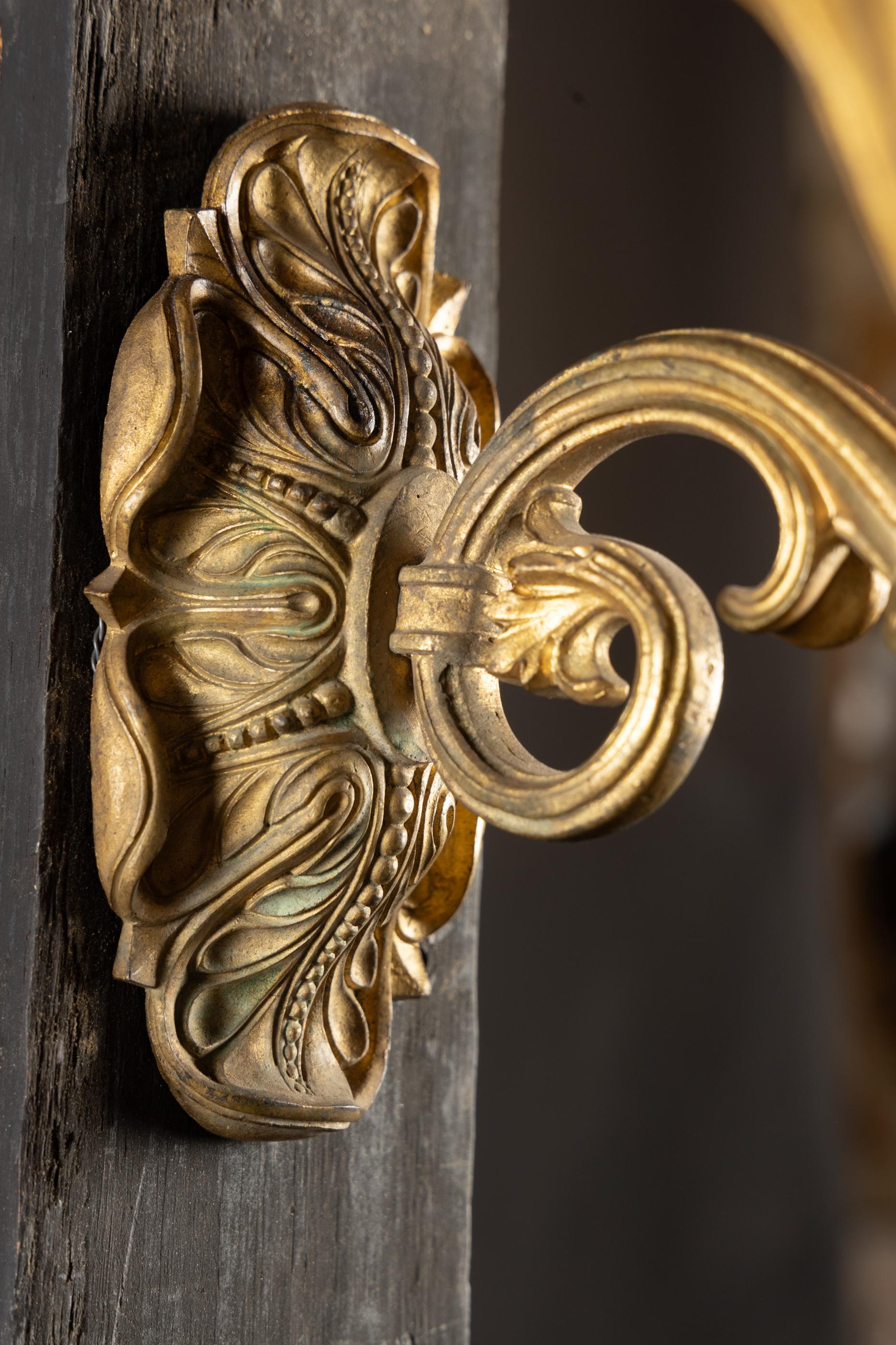 Nous vous présentons une magnifique applique en bronze d'Ore de style Empire du 19e siècle. La pièce présente une plaque arrière ornée, un fleuron à feuilles détaillées en bas et une belle flamme au centre en haut. Chaque bras est orné de jolies