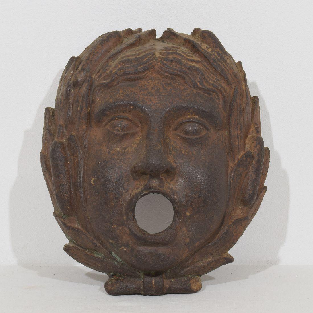 Beautiful and very rare Empire cast iron laureled fountain head with a great expression, France, circa 1800-1850. Weathered.